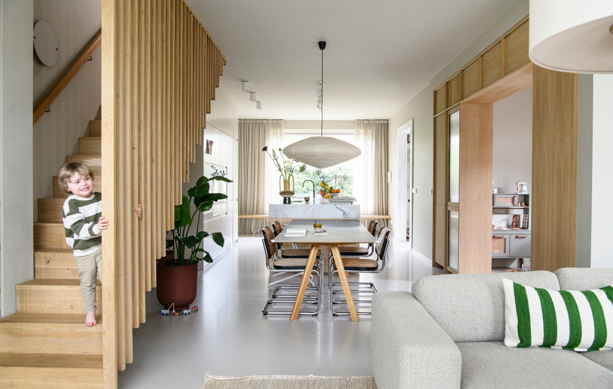Tafel Cph 30 van Hay, stoelen Cesca B32 van Marcel Breuer, papieren hanglamp Akari 15a van Vitra. Spots in de keuken Solid 1.0 en Sqube on track van Wever &amp; Ducré. Bloempot Vig in Burnt Henna van House Doctor, zitbank Sepia in stof Monza van Bolia, kussen Household Hardware. Keukentje in speelhoek eigen Ikea-hack. vtwonen 01-2025 | styling Esther Loonstijn | fotografie Louis Lemaire
