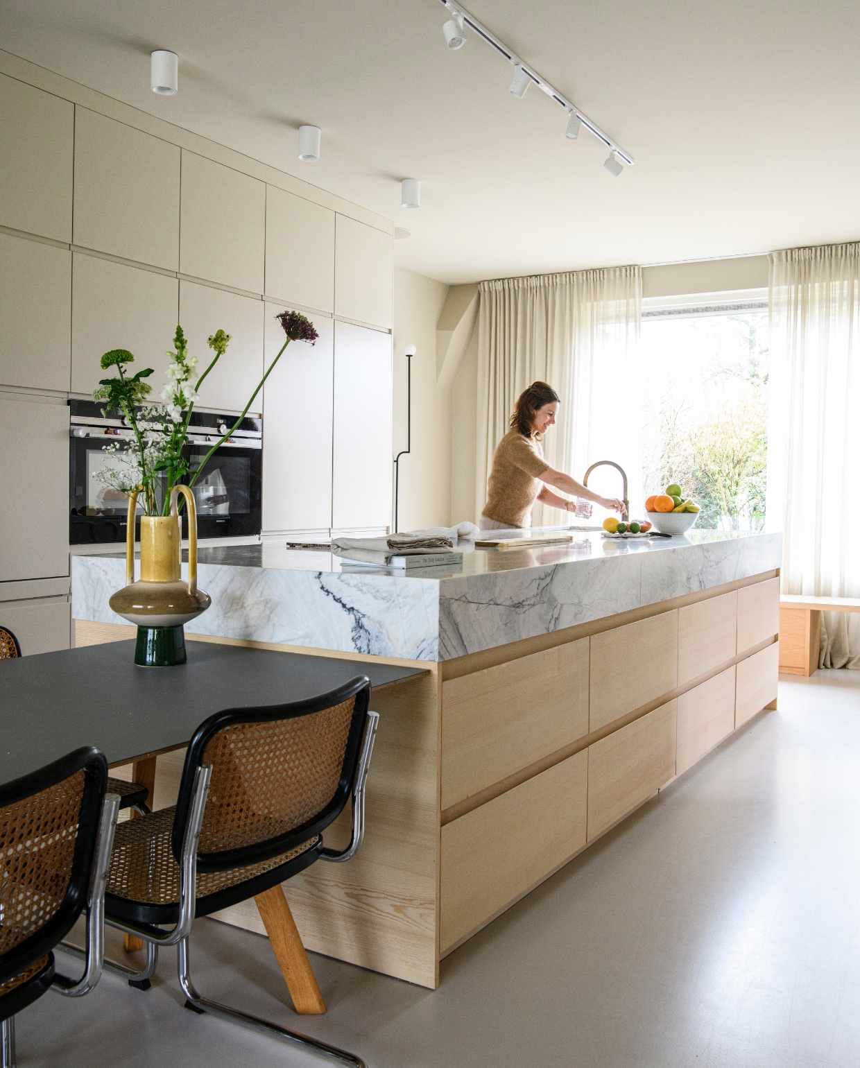 Keuken op maat naar ontwerp van Avenue Design Studio, marmer van SolidNature en grenenhout via De HoutFabrique. Gordijnen Aristide, zwarte muurlamp Mobil 150 van Pholc. vtwonen 01-2025 | styling Esther Loonstijn | fotografie Louis Lemaire