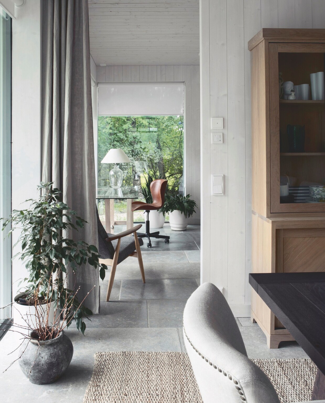 Vloerkleed Dixie. Kalkstenen vloer in Burford Grey van Ekland Stone. Vintage leren bureaustoel uit 1950, opnieuw bekleed. Leunstoel erfstuk van Rauls ouders. vtwonen landelijk 01-2025 | styling &amp; fotografie Heikki Rautio