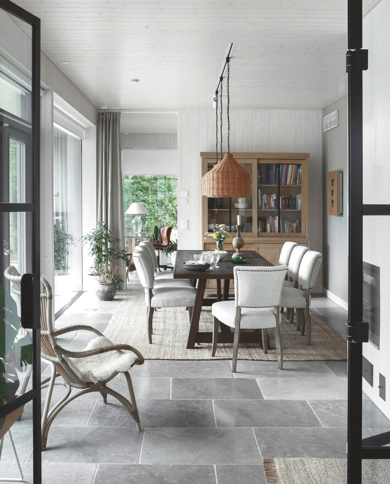 Eettafel en vitrinekast van Neptune. Eetkamerstoelen van Artwood. Handgevlochten hanglampen van een Oekraïense ambachtsman via Etsy. vtwonen landelijk 01-2025 | styling &amp; fotografie Heikki Rautio