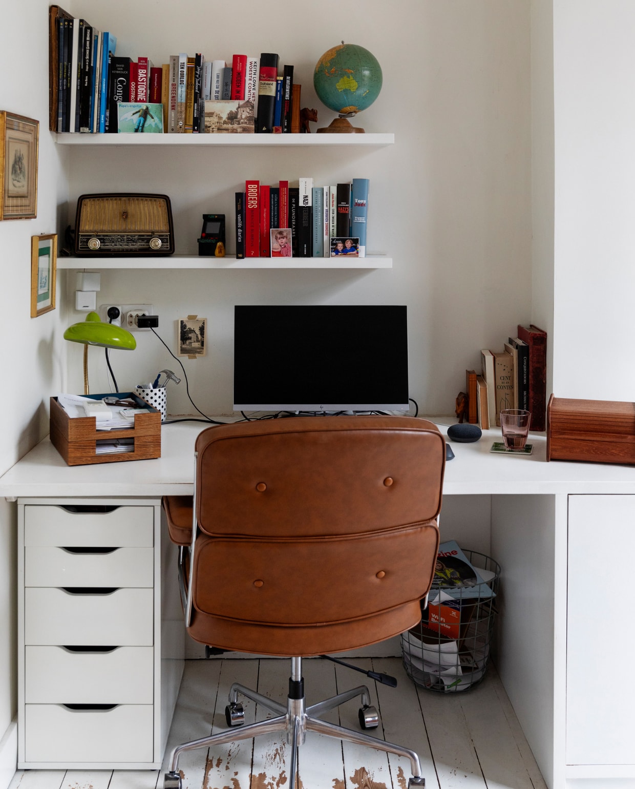 Verf muur en vloer Ral 9010. Bureau  en planken op maat laten maken. Globe, schilderijen en bureaulamp rommelmarkt en kringloop. Postvak Ferm Living, bureaustoel Cavel Design. Overig onbekend. vtwonen 10-2023 | styling Ilona Jongepier | fotografie Dana van Leeuwen