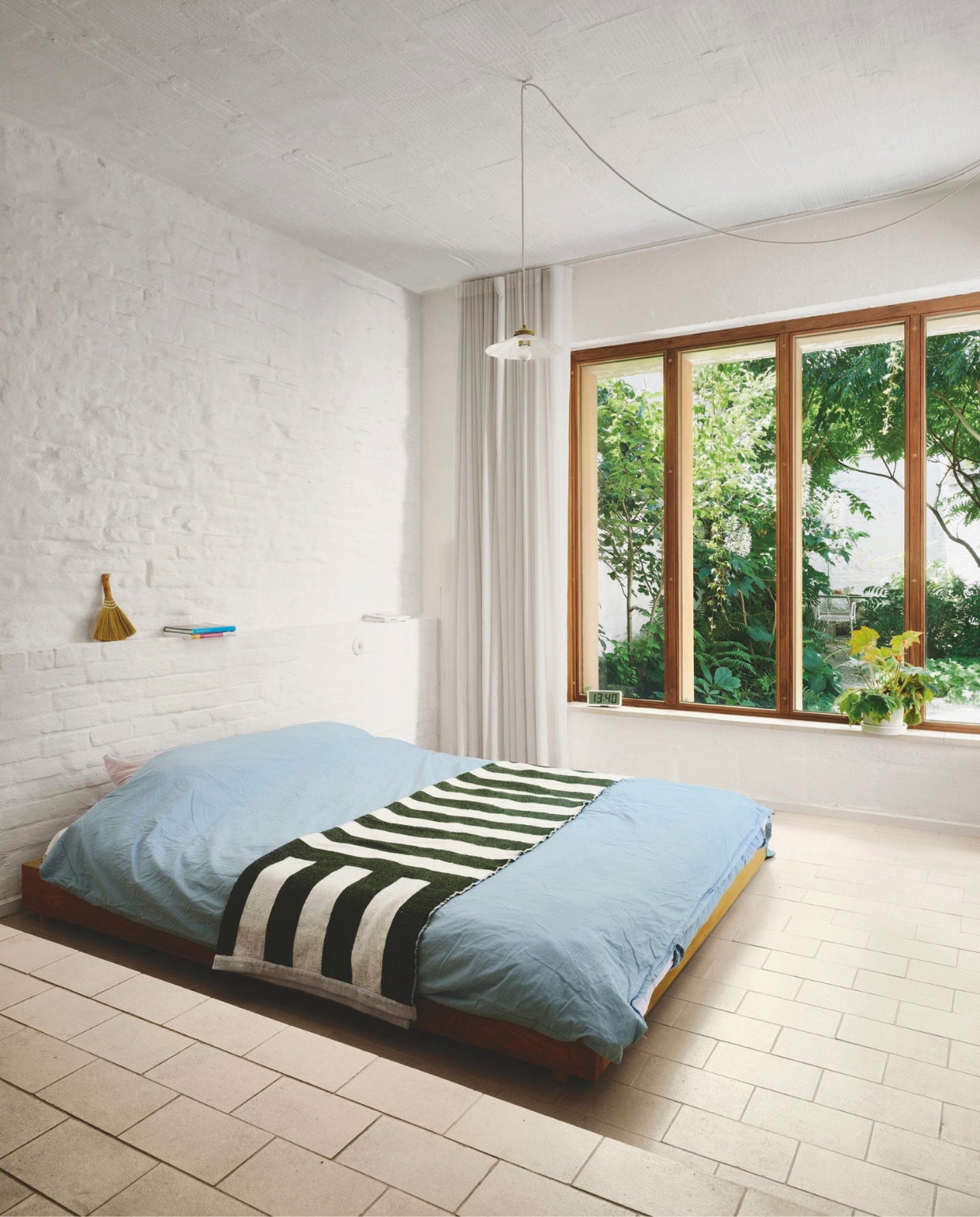 Een aanbouw maakte plaats voor een slaapkamer op de begane grond, met zicht op de weelderige stadstuin. Bed zelfgemaakt, hanglamp Rotor. stijlvol wonen 02-2025 | productie Living Inside | fotografie Mr. Frank