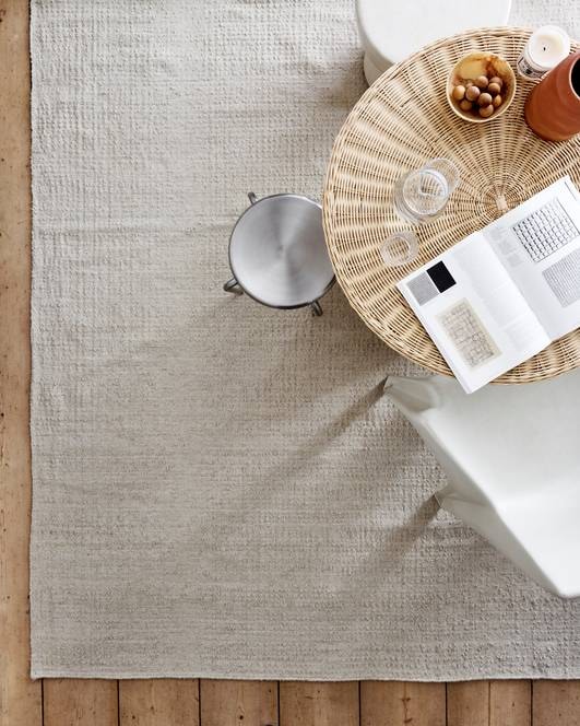 Vloerkleed Ripples, 160x230 cm € 179 en 200x300 cm € 279. M.m.v. householdhardware.nl (rotan tafel, tadelakt kruk), zarahome.nl (aluminium kruk, vaas), redesignvintage.nl (stoel), sissy-boy.com (schaal), astierdevillatte.com (geurkaars). Overig privébezit. styling Marlies Does | fotografie Sjoerd Eickmans
