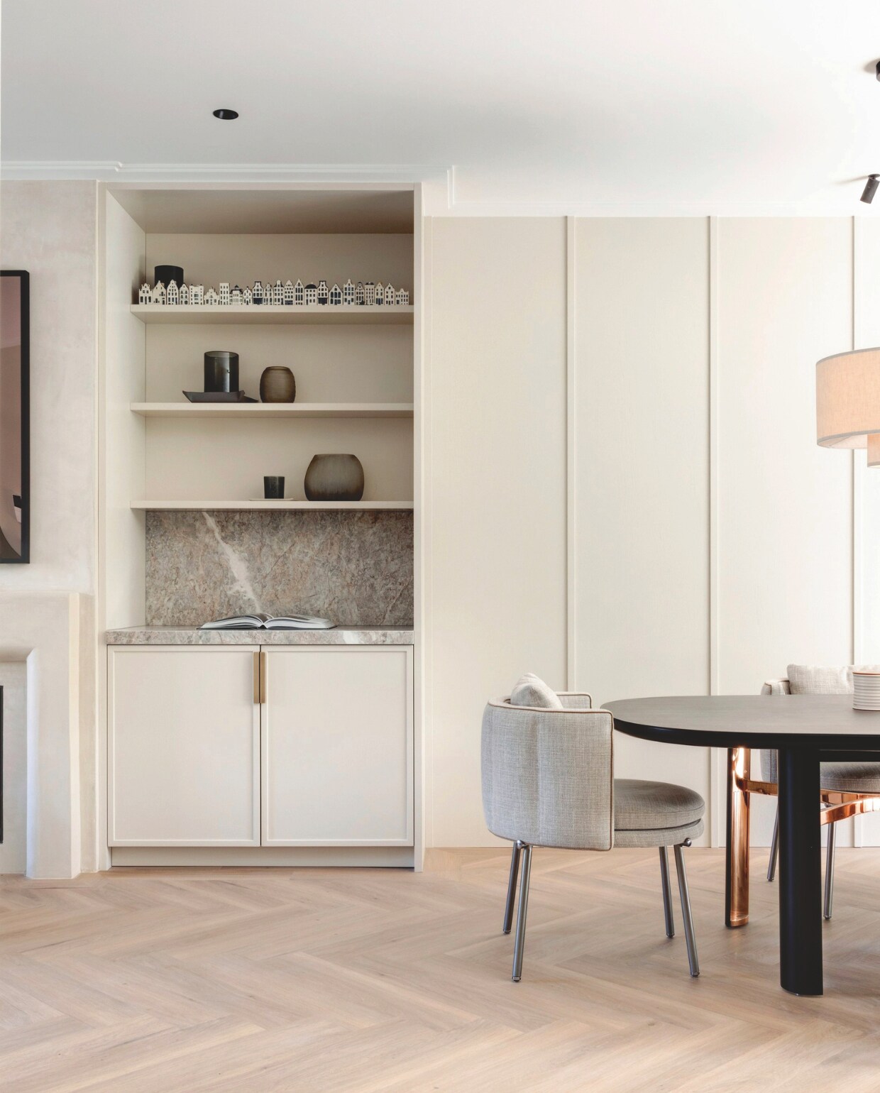 Het wandmeubel kreeg dezelfde kleur als de keuken, Rolling Fog van Little Greene. Ook hier een nis in marmer, om te benadrukken dat de eetkeuken als een geheel functioneert. In de kast vazen van Guaxs en porseleinen KLM ‘verzamelhuisjes’. stijlvol wonen 2-2025 | fotografie Jurrit van der Waal | tekst Yvonne van Galen