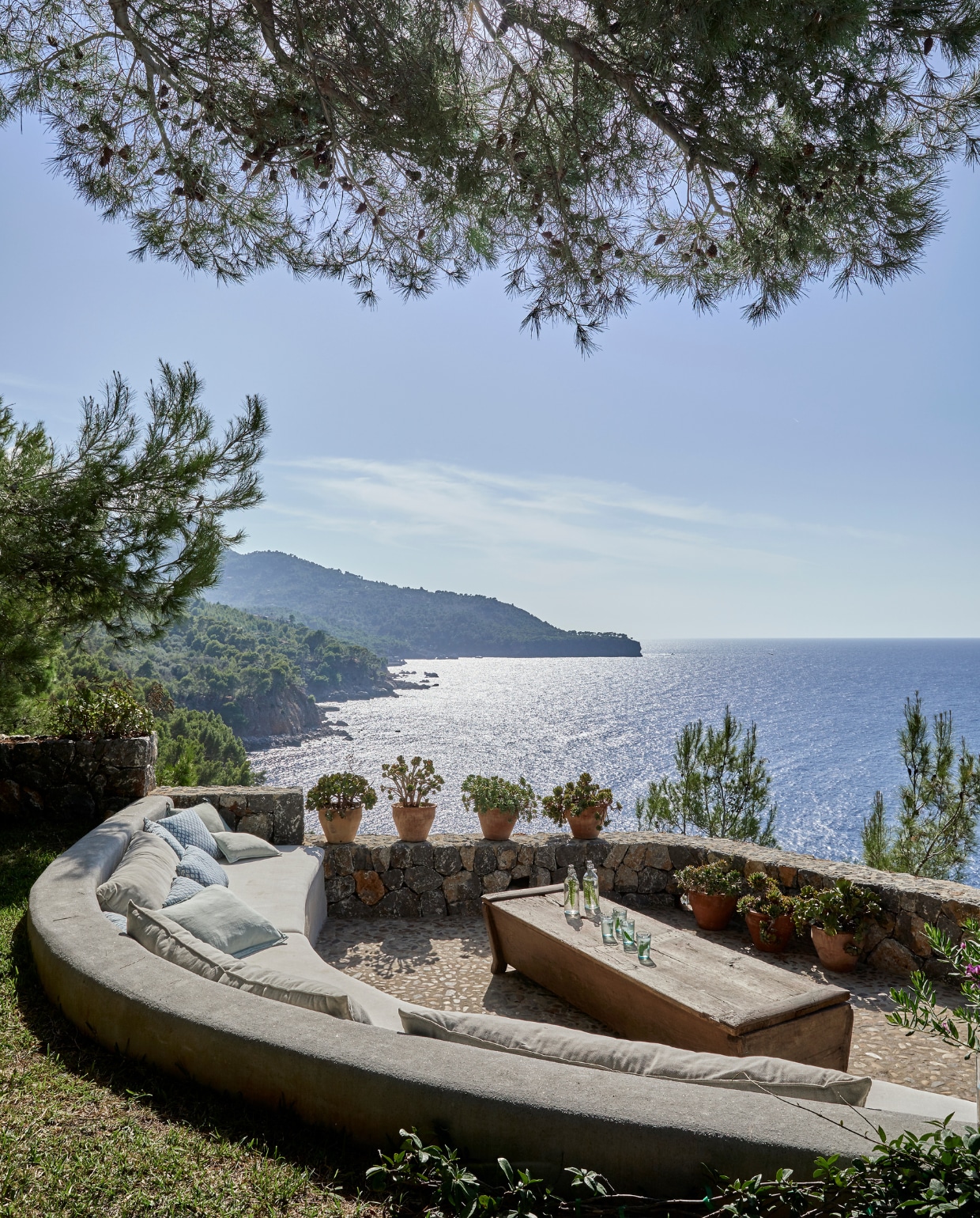 Om maximaalte genieten van het spectaculaire uitzicht op de Middellandse Zee is een uitkijkpunt gecreëerd, twee terrasniveauslager dan het huis. Vintage drankentafel van een antiekwinkel op Mallorca. De banken zijn ingebouwd. vtwonen 02-2025 | Styling Tille Del Negro | Fotografie Greg Cox | Tekstbewerking Wilma Tjalsma-Smits