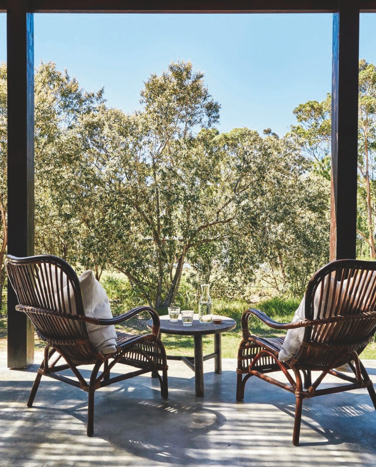 De kleinere veranda bij Nguni Cottage biedt een eindeloos uitzicht. Anatolische herdershonden Sirius en Luna zoeken hier verkoeling op de betonnen vloer tijdens het heetste moment van de dag. Soortgelijke hondenmand Rivièra Maison. vtwonen landelijk 02-2025 | Styling Luanne Toms | Fotografie Elsa Young | Tekstbewerking Mirjam Rosema-Verhulst