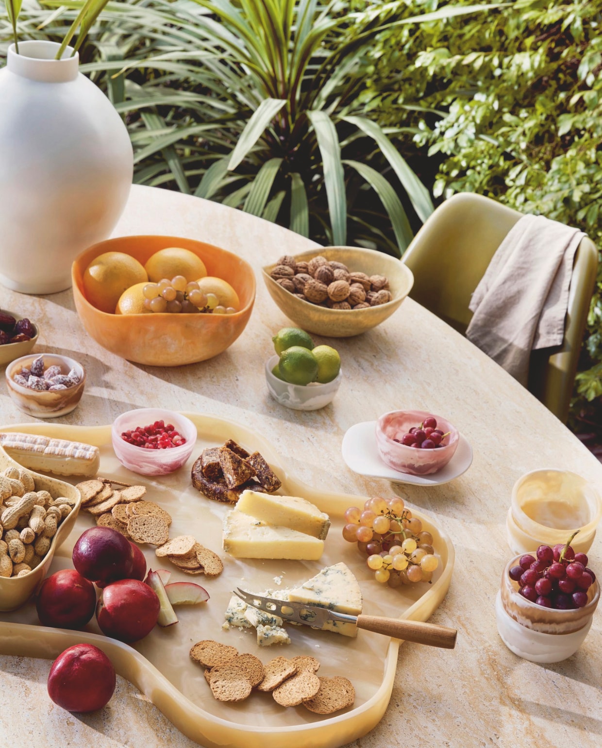 Harspolyester schaal Patio Mustard € 49,95, harspolyester schaal Patio Orange € 94,95, harspolyester schaaltje Patio in verschillende kleuren € 16,95, harspolyester dienblad Patio Cream € 189,- (hkliving.com). Ecocomposiet tafel Myrna Travertin van Giga Meubel, 200x100x75 cm (lxbxh) € 1399,-, polyester stoel Tulip Curry Groen van Household Hardware, 60x58x80 cm (bxdxh) € 119,-, keramieken vaas Hush van Urban Nature Culture € 59,95 (shop.vtwonen.nl). vtwonen 03-2025 | styling kelly van gendt | fotografie peggy janssen