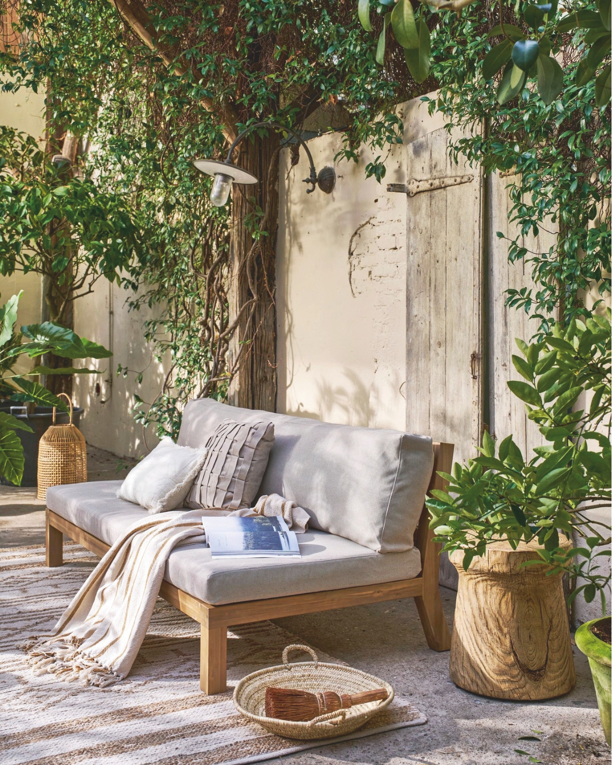 Acaciahouten driezits buitenbank Relax in Naturel/Zand, 180x70x90 cm (bxdxh) € 749,-.M.m.v.: madamstoltz.nl (vloerkleed, houten salontafel, mand, plaid, kussens, glazen fles met rieten handvat), nordal.dk (windlicht), Iblaursen.nl (gevlochten lampion, kom), shop.vtwonen.nl (glazen uit de vtwonen collectie), basiclabel.nl (houten bijzettafel van Woood), householdhardware.nl (schaal van tadelakt). Overig privébezit. vtwonen landelijk 03-2025 | Styling Cleo Scheulderman | Fotografie Jeroen van der Spek