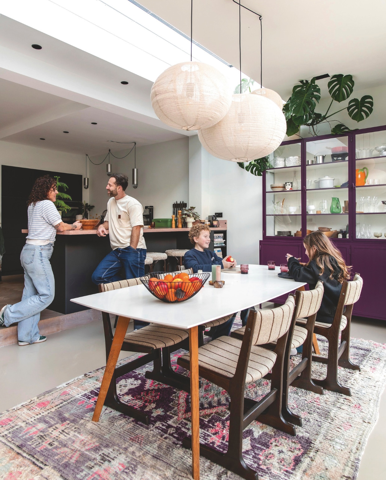 Tafel Wehkamp. Stoelen vintage. Fruitmand Pt. Bollampen Zara Home. Kleed Living Maroc. Paarse kast Oldwood. Aardewerk en glazen vintage. Oranje kan Casa. Groene vaas Polspotten. Beker met gezicht Kitsch Kitchen. Beige schaal met streep HKliving. Keukeneilandkasten Kvik, maatwerk blad Pronck. Bruine schaal Dille &amp; Kamille. Witte bloempot vintage. Vintage barkrukken bekleed met schapenvacht Van Buren Bolsward. vtwonen 03-2025 | fotografie studio keeelly | tekst caroline westdijk