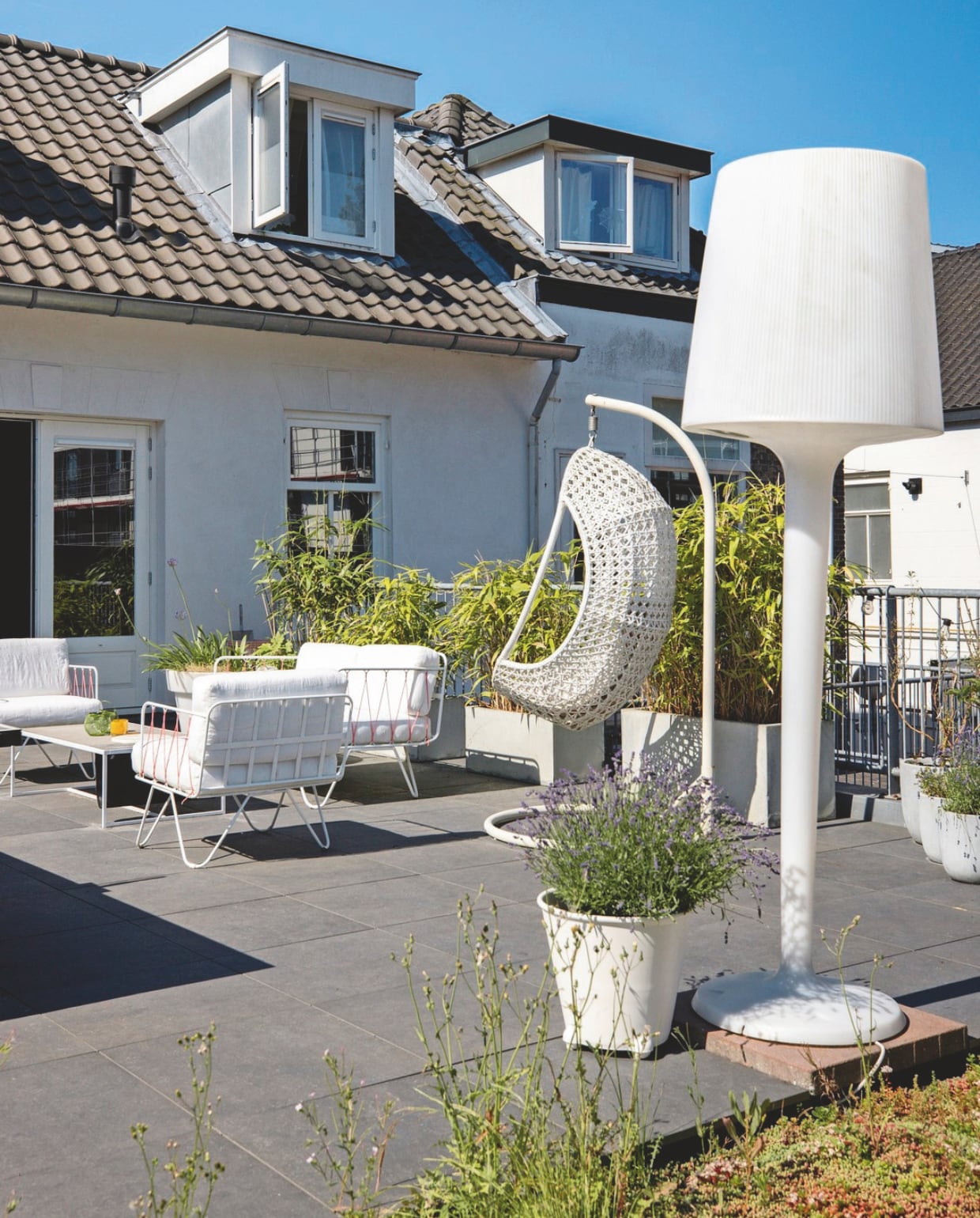 Staande lamp Paardekooper-Hulst. Tuinset Honoré Design voor Serax. Hangstoel Sens-Line. Grote witte bloempot Ikea, overige bloempotten Intratuin. vtwonen 03-2025 | fotografie Margriet Hoekstra
