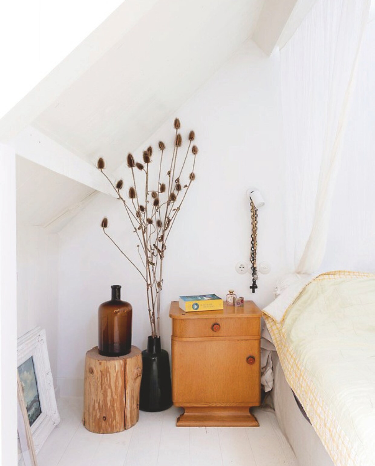 Nachtkastje vintage uit Polen. Nachtlamp Hue van Philips. Vaas erfstuk. Boomstam uit tuin familie. Muurverf Ral 9010. vtwonen 03-2025 | fotografie margriet hoekstra | tekst adeline mans