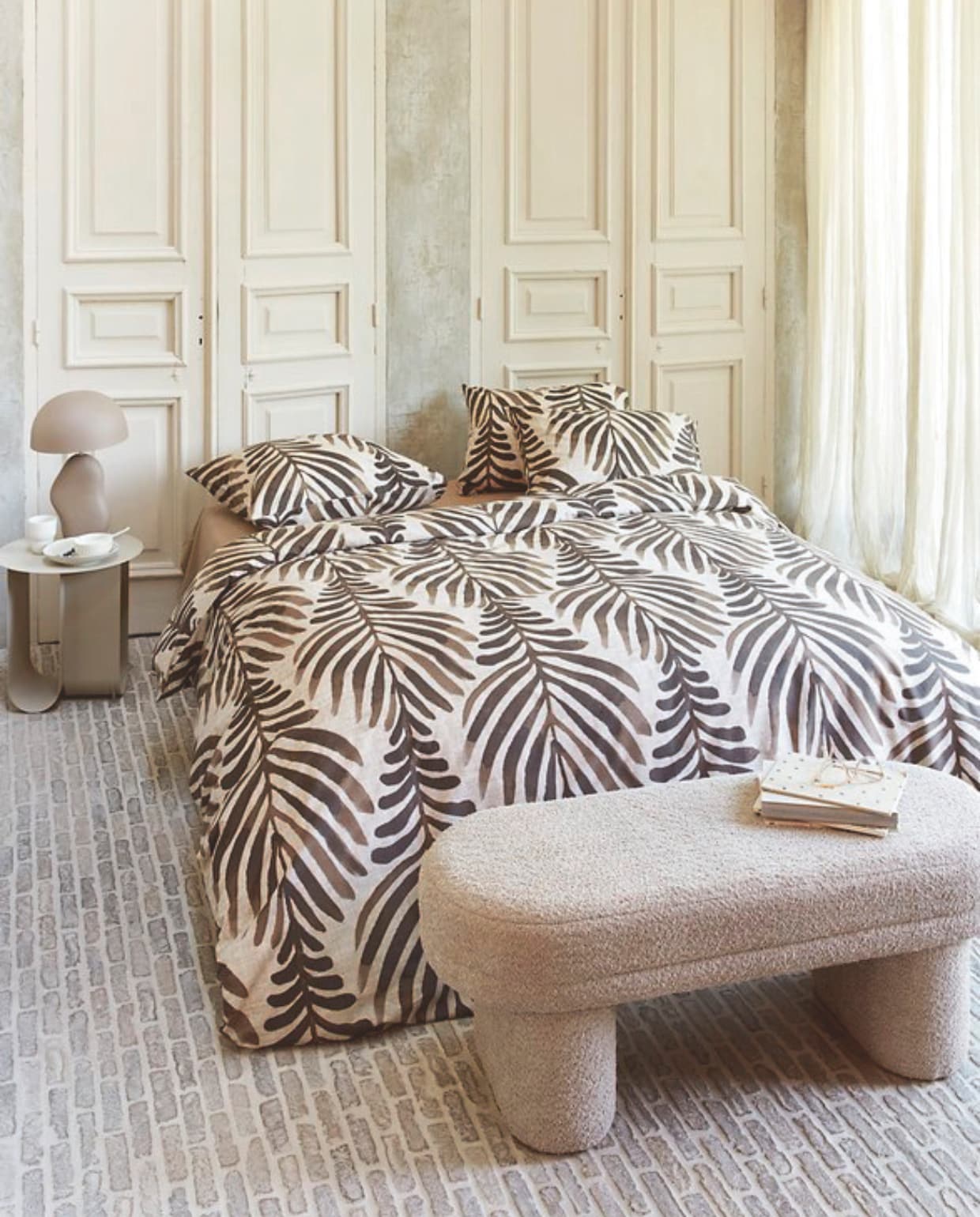 Katoenen dekbedovertrek Bold Feathers in Zand vanaf € 49,95. M.m.v. by-boo.com (nachtkastje, tafellamp, stoffen bank), kwantum.nl (mok en bord). Overig privébezit. vtwonen 04-2025 | styling Kim Timmerman, Danielle Verheul | fotografie Richard Smit