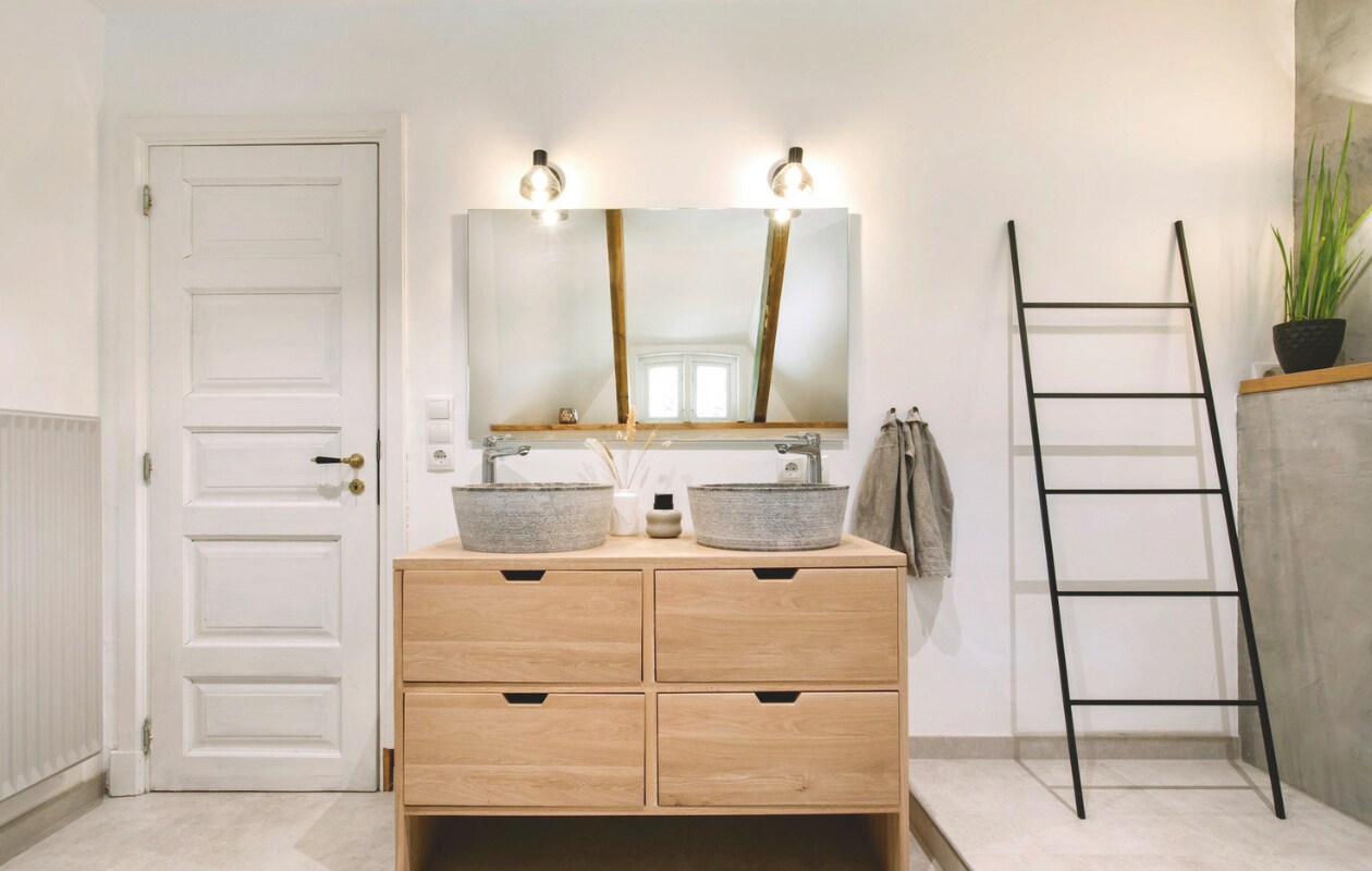 Vloer van beton. Vergelijkbaar houten wastafelmeubel Van Heck Badkamers. Soortgelijke kapstok-ladder Estivar van La Redoute. vtwonen Landelijk 03-2025 | Styling Miriam Hannemann | Fotografie André Reuter | Tekst Joëlle Baelde