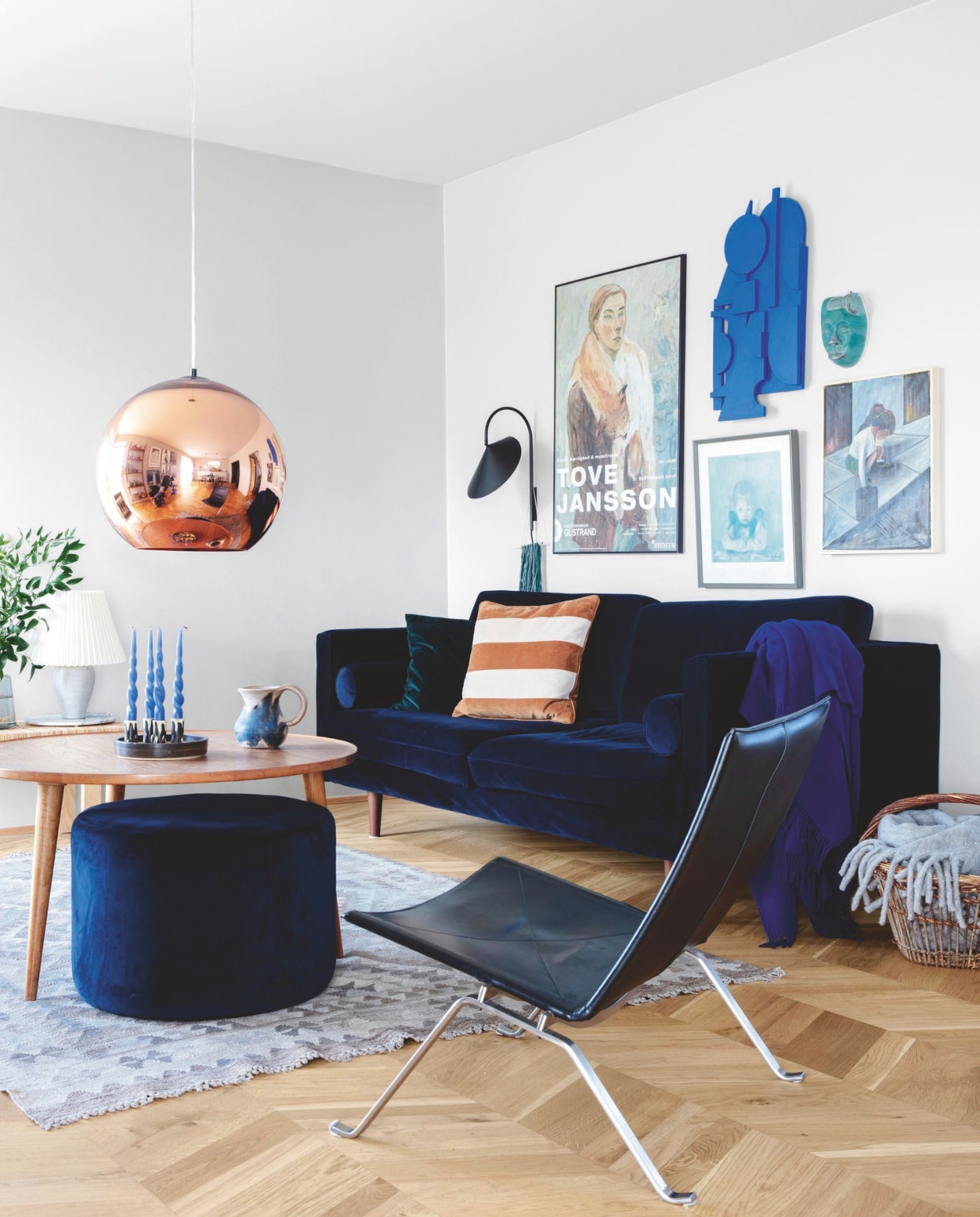 Bank en poef Sofacompany, plaid Silkeborg Uldspinderi. Wandlamp Ferm Living, hanglamp Tom Dixon. Kleed Tine K Home, zwarte stoel Poul Kjærholm. Accessoires kringloopvondsten. Wandsculptuur zelfgemaakt door Lone. Lichtgrijze muur- en plafondkleur NCS S 2000-N vtwonen 04-2025 | styling Rikke Graff Juel | fotografie Christina Kayser O
