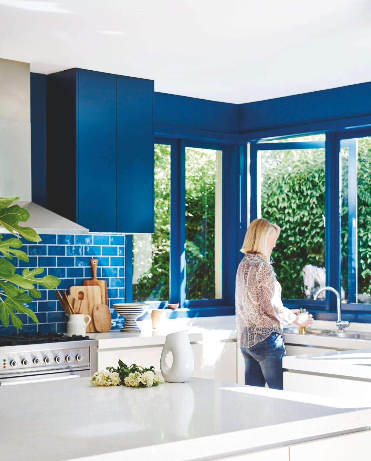 Muurkleur afgestemd op Hague Blue van Farrow &amp; Ball. Wandtegels Azul Zafiro via Signorino. Melkkan, lepels en fruitschaal vintage. Gestreepte schaal Tom Dixon. vtwonen 04-2025 | styling Fiona Richardson | fotografie Lisa Cohen