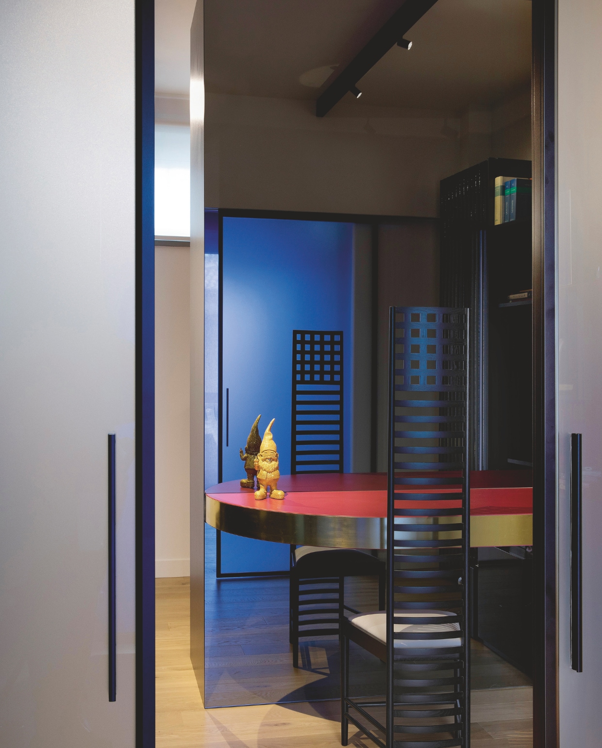 De iconische stoel Hill House van Mackintosh in de studeerkamer. Kasten van gerookt glas. Stijlvol Wonen 04-2025 | fotografie Barbara Corsico | tekst Jackie Oomen | Productie Living Inside / Brontekst Marzia Nicolini