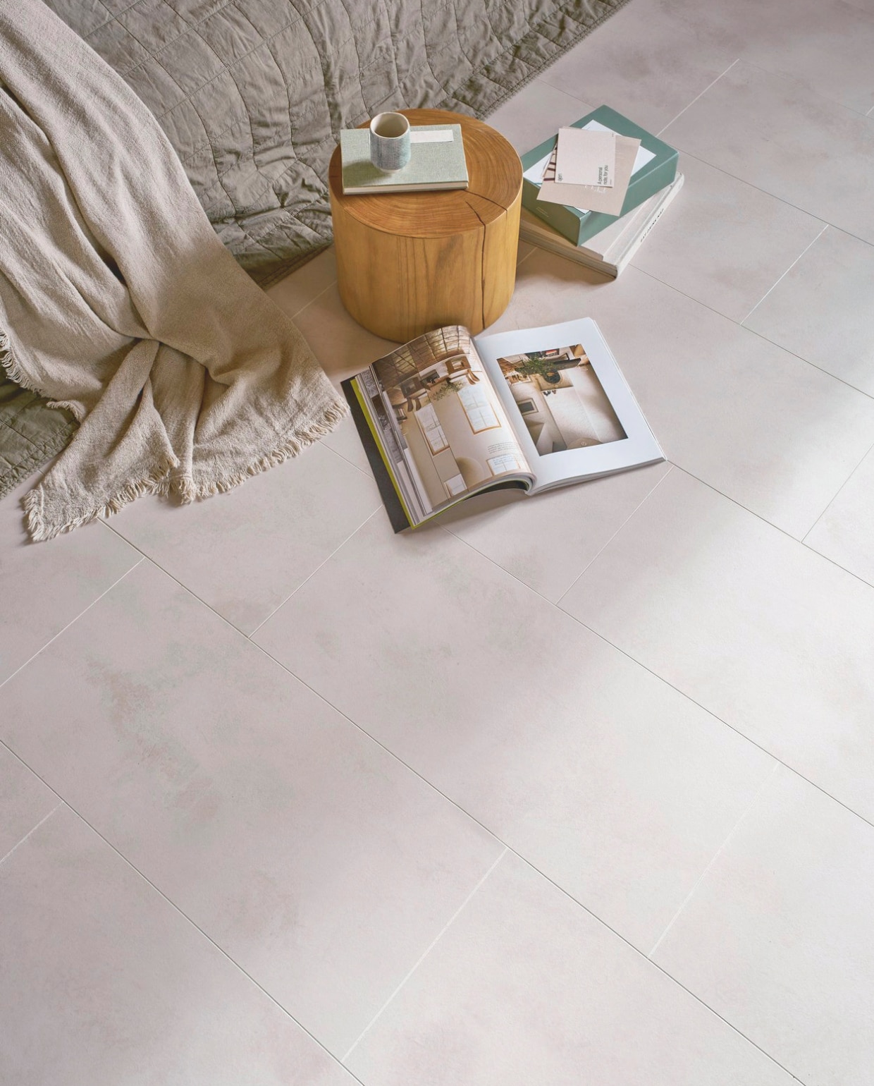 Laminaat XL in Crème Beton, lamel 138x32,6x0,8 cm, met groef, per m² € 32,99.M.m.v. zarahome.com (sprei, mok), urbannatureculture.com (bijzettafel). Overig privébezit. vtwonen 05-2025 | styling Cleo Scheulderman | fotografie Jeroen van der Spek