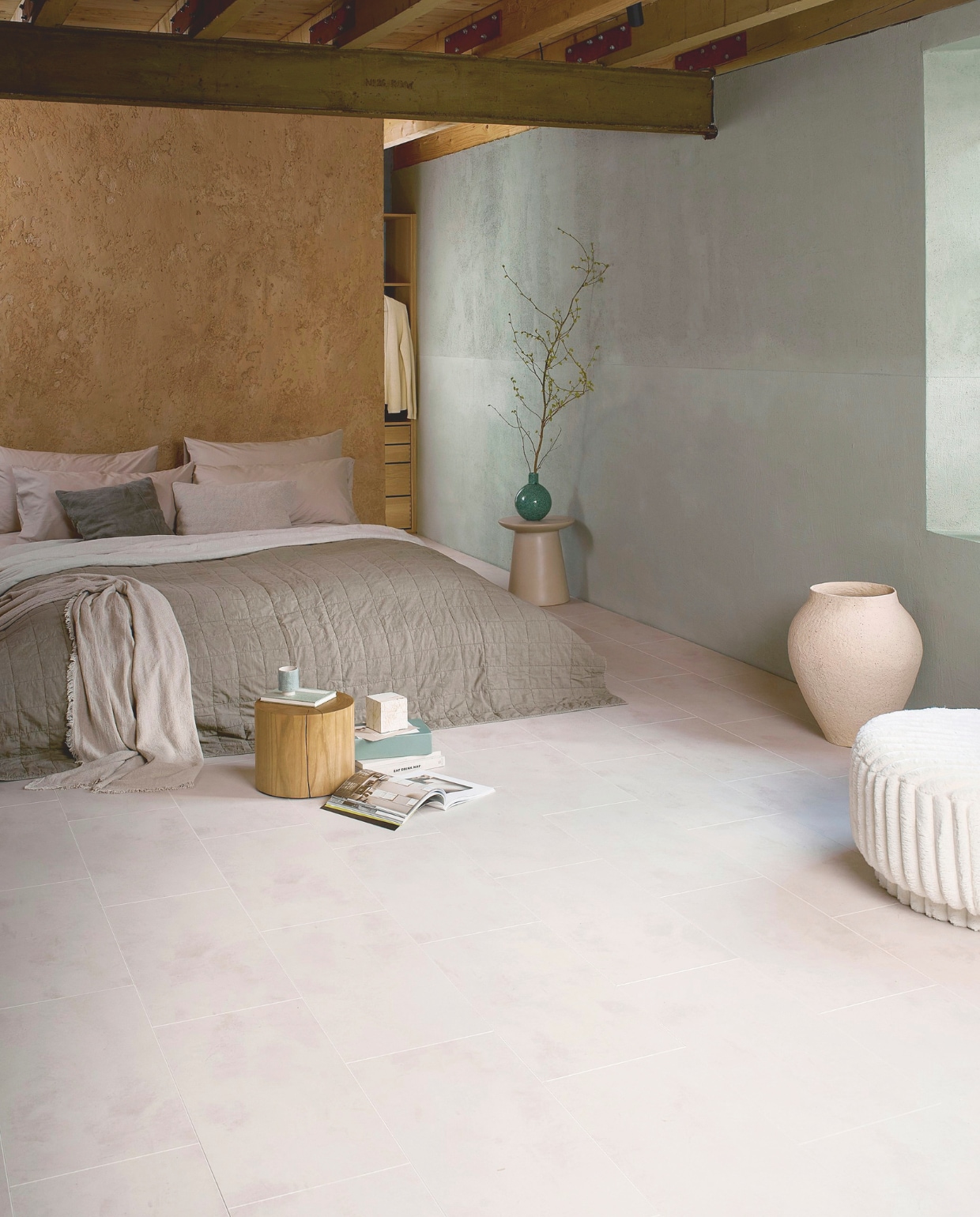 Laminaat XL in Crème Beton, lamel 138x32,6x0,8 cm, met groef, per m² € 32,99.M.m.v. zarahome.com (sprei, mok, kubus), rapture.amsterdam (fauteuil), urbannatureculture.com (zeegroene vaas, pot, bijzettafel), dofine.nl (wandafwerking.nl). Overig privébezit. vtwonen 05-2025 | styling Cleo Scheulderman | fotografie Jeroen van der Spek