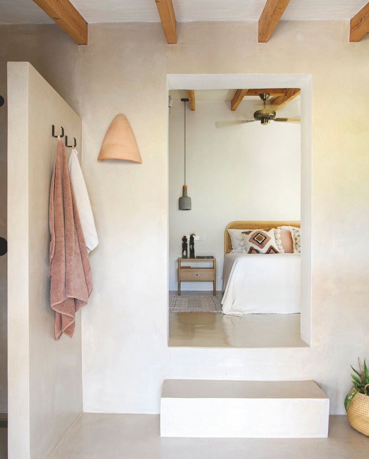 Bed lokaal beddenbedrijf. Kussens H&amp;M Home. Nachtkastje Ethnicraft. Lampen Dutchbone. Mat, handdoeken en sprei Zara Home. Beelden souvenirs uit Afrika. Wandhaken op maat laten maken bij metaalbedrijf. Wandlamp van lokaal keramiekbedrijf. vtwonen zomerboek 2025 | styling Inge van Lieshout | fotografie Louis Lemaire | tekst Merel van der Lande