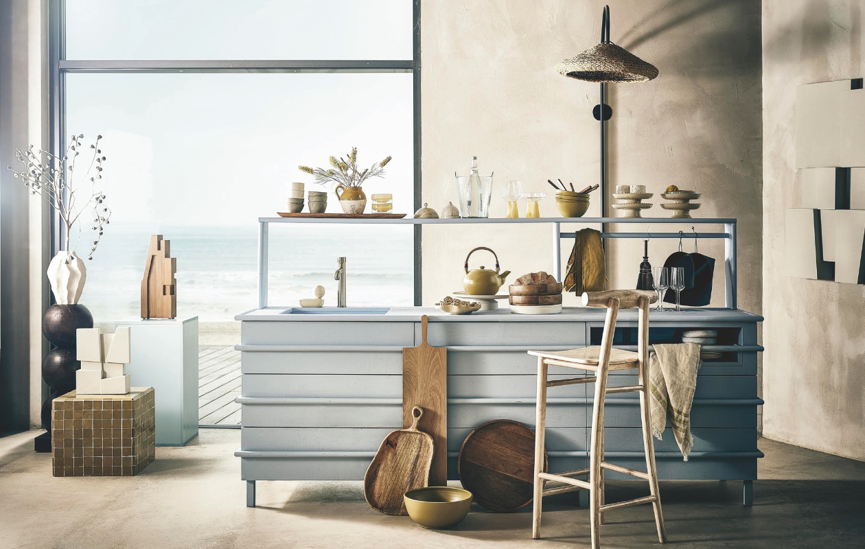 Maatwerk keuken, prijs op aanvraag (com-anders.nl). Wandkunstwerk Modern Shapes € 1695,-, witte sculptuur € 195,-, blauw blok € 65,-, keramieken zeepbak Boule Vanille van April van Domburg x Edith Beurskens € 120,- (edithbeurskens.com). Houten sokkel Bulb, 28x83 cm (Øxh) € 299,-, houten object Vieste XL € 89,99, houten XL-bord Gila € 59,99 en houten dienblad Lang Golden Oak € 52,99 van Urban Nature Culture, betegelde bijzettafel Zellige van Household Hardware, 40x40x40 cm € 499,- (shop.vtwonen.nl). Witte keramieken vaas € 39,99, houten serveerplank met oor € 32,99, organische porseleinen schaal € 24,99, houten schaal € 29,99  (hm.com). Witte serveerschaal € 109,90, stoffer en blik € 90,-, wijnglas Serax € 22,90, witte diepe borden € 34,-, grote houten broodplank € 90,- (letoile.store). Mosterdkleurige doek € 99,-, mosterdkleurige schaal € 149,95, keramieken theepot Olive € 90,- (sukha.nl). Gestreepte linnen gastendoek The Belgian Towel, 55x65 cm € 38,- (libecohomestores.eu). Op de plank v.l.n.r.: houten dienblad Lang Golden Oak van Urban Nature Culture  € 52,99 (shop.vtwonen.nl), witte keramieken koffiekop Alabaster Dune van Kelly Wearstler voor Serax, set van 2 € 32,- (letoile.store), Japanse schaaltjes € 39,-, terracotta kan € 49,99 (zarahome.com), glazen schaaltjes Claude van Brût Homeware, set van 4 € 42,50 (shop.vtwonen.nl), stolp met schotel € 69,90 (letoile.store), knoflookvormige stolp met schotel € 9,99 (hm.com), glazen wijnkoeler Crinkle van Urban Nature Culture € 69,99, wijnglas en coupe Claude van Brût Homeware, set van 2 € 39,95 (shop.vtwonen.nl), keramieken soepkom Olive € 26,- (sukha.nl), houten bestekset 70’s € 149,- (hkliving.com), bord op voet Zigzag van Household Hardware € 39,95 (shop.vtwonen.nl), wit gestructureerd schaaltje € 22,90 (letoile.store). Overig locatie- en privébezit. vtwonen 05-2025 styling | styling Liza Wassenaar | fotografie Sjoerd Eickmans