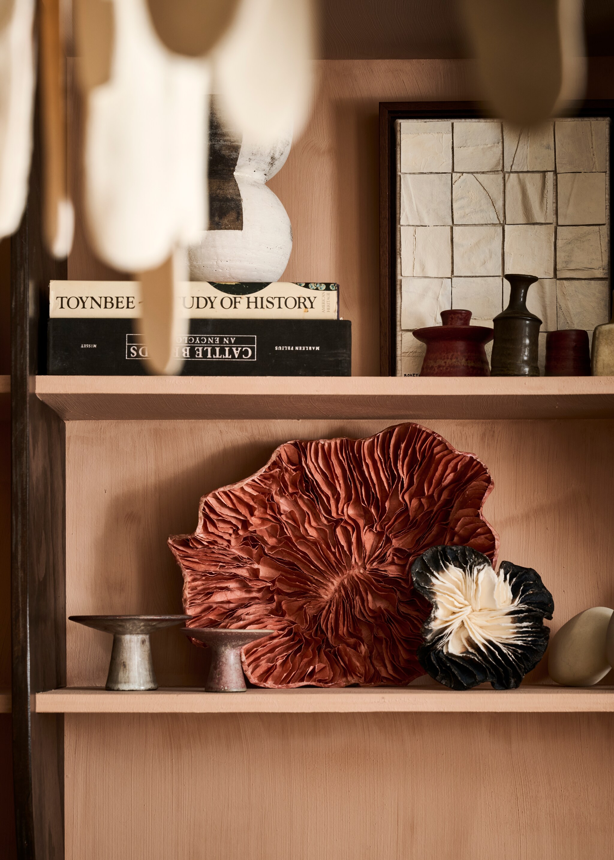 Wandkasten op maat gemaakt door Combitex, prijs op aanvraag (com-anders.nl). Zwamvormige kunstobjecten op planken (elsavisser.com). Bekijk alle overige productinformatie via go.vtwonen.nl/vt7-2025. vtwonen 07-2025 | styling Liza Wassenaar | fotografie Sjoerd Eickmans