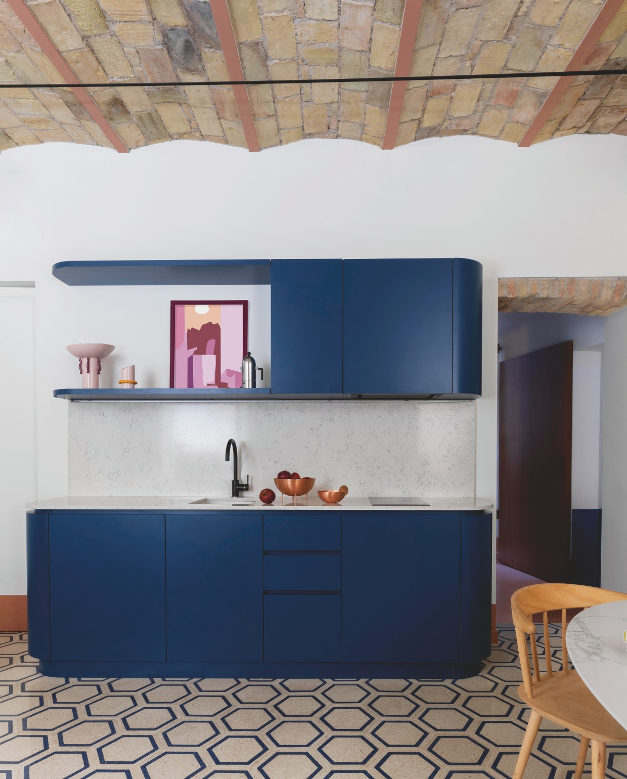 Keuken met Silestone-werkblad op maat gemaakt door Studio Tamat. Kraan Franke. Kommen op aanrecht uit de Lunar Landscape-collectie van Elisa Ossino voor Paola C. Vazen Arianna De Luca. Print Irena Pavlyshyn. Koffiezetapparaat van Aldo Rossi voor Alessi. Stijlvol Wonen 04-2025 | styling Francesca Sironi | fotografie Monica Spezia | tekstbewerking Tanne Donjarcour Gielen | prouctie Living Inside | tekst Francesca Sironi
