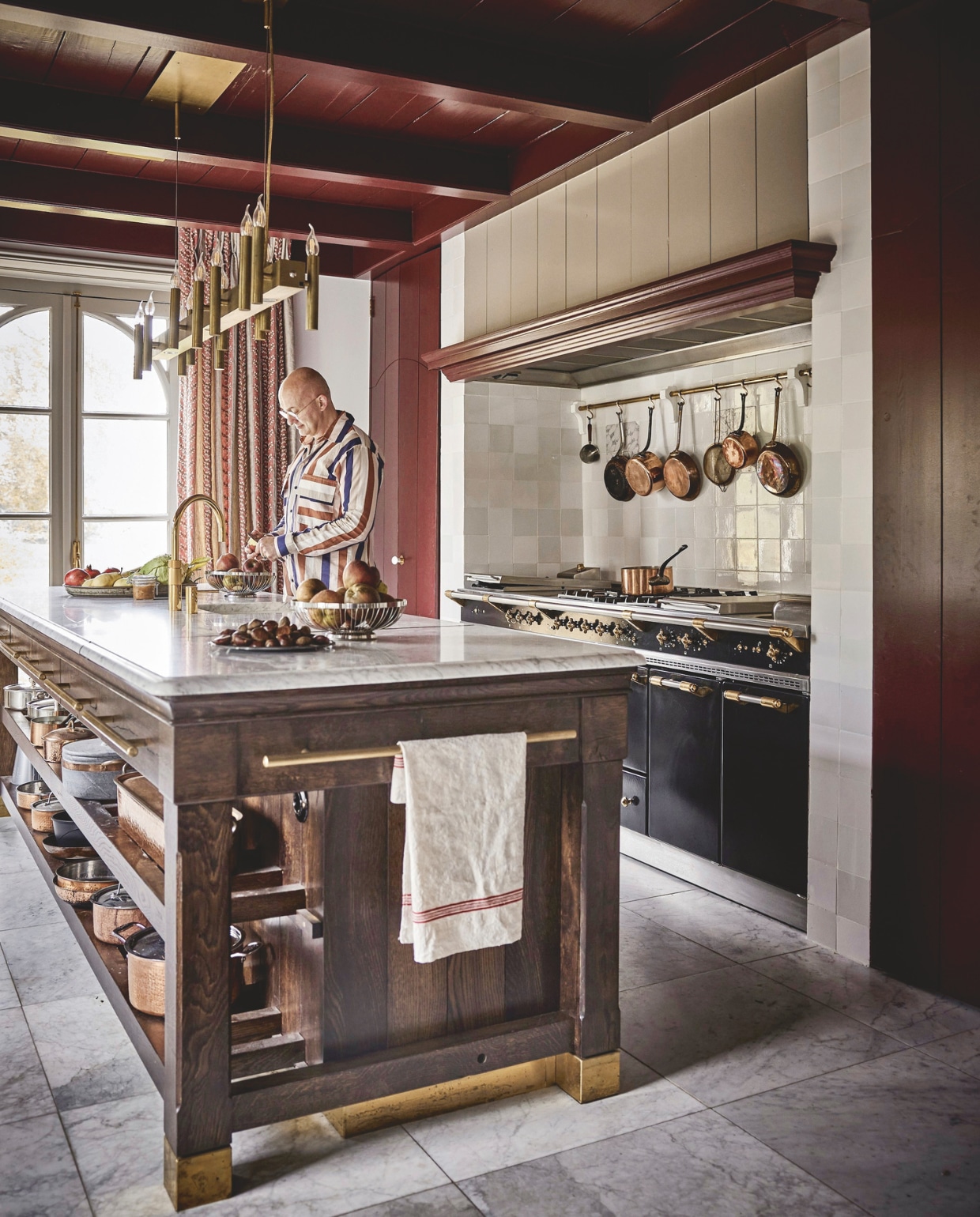 Keukenblok gemaakt door Hans Tinga. Lamp Brand van Egmond. Gordijnen Woodbridge Nina Campbell. Kraan Quooker. Fornuis Lacanche. Theedoek van19e-eeuws Frans linnen van veiling. Koperen pannen van over de hele wereld. Witjes Het Friese Tegelboertje. Marmeren tegels Amata Carrara. Kleur houtwerk Persiaans rood Vettewinkel. vtwonen landelijk 01-2025 | styling Marianne Luning | fotografie Alexander van Berg