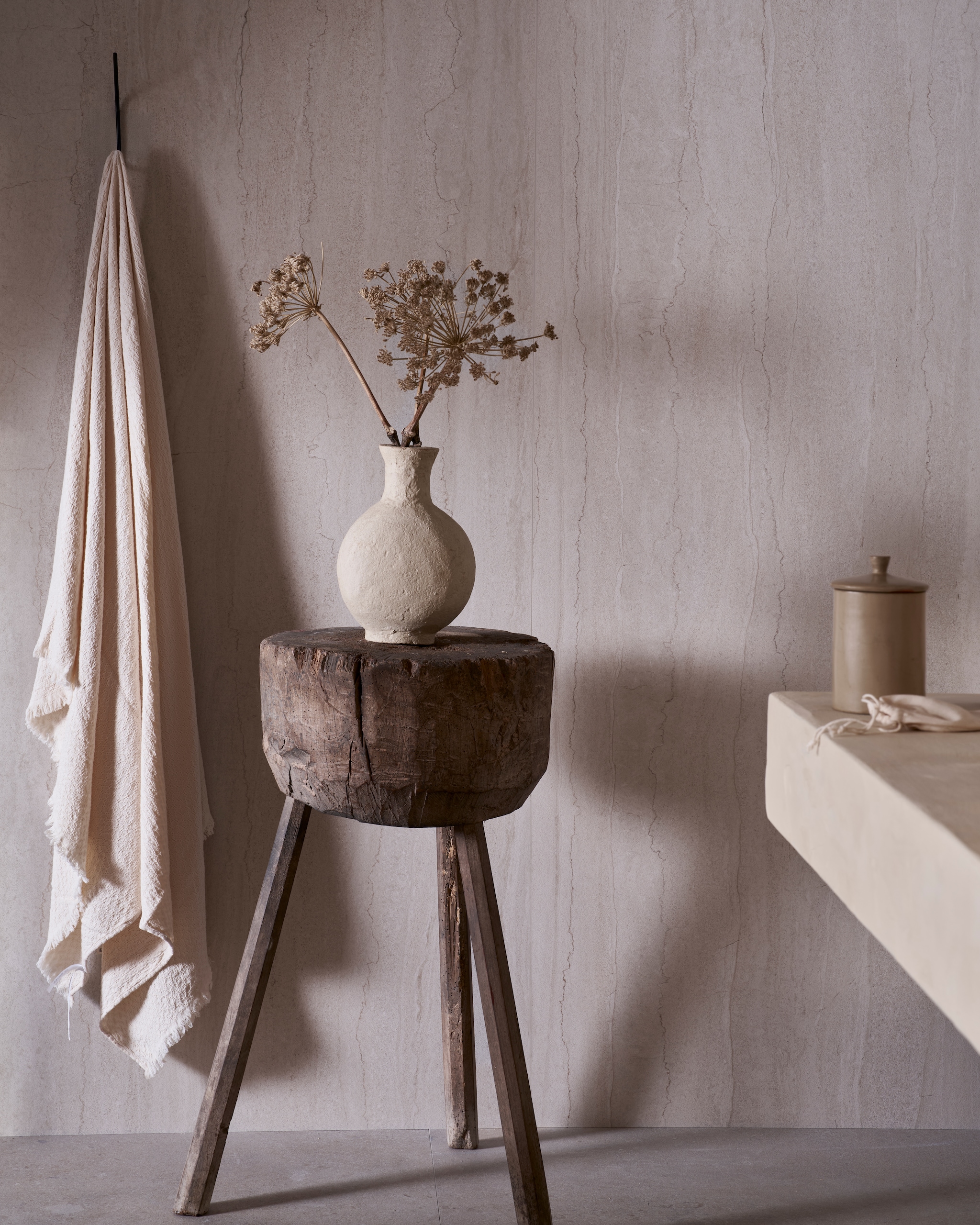 vtwonen tegel Portland Travertine in Marfil 120x280 cm, per m² € 99,50. M.m.v. 1. pietjonker.nl (houten bijzettafel), weldaad.com (vaas), zarahome.com (handdoeken). Overig privébezit. vtwonen Landelijk | fotografie Jeroen van der Spek | styling Cleo Scheulderman