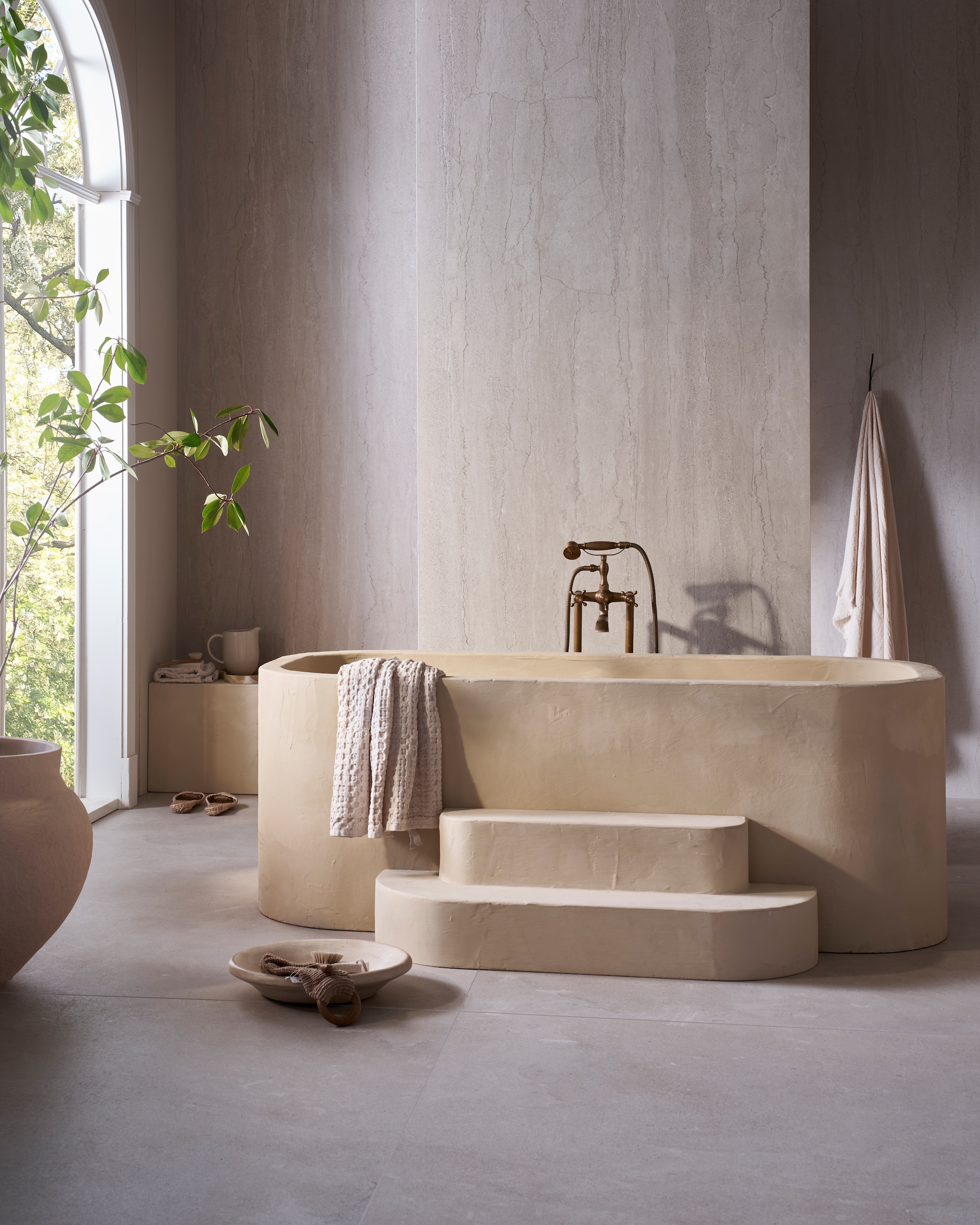 vtwonen tegel Portland Travertine in Marfil 120x280 cm, per m² € 99,50. weldaad.com (houten pot en vaas), urbannatureculture.com (katoen-maché pot), zarahome.com (handdoeken), householdhardware.nl (schaal van tadelakt). Overig privébezit. vtwonen Landelijk | fotografie Jeroen van der Spek | styling Cleo Scheulderman