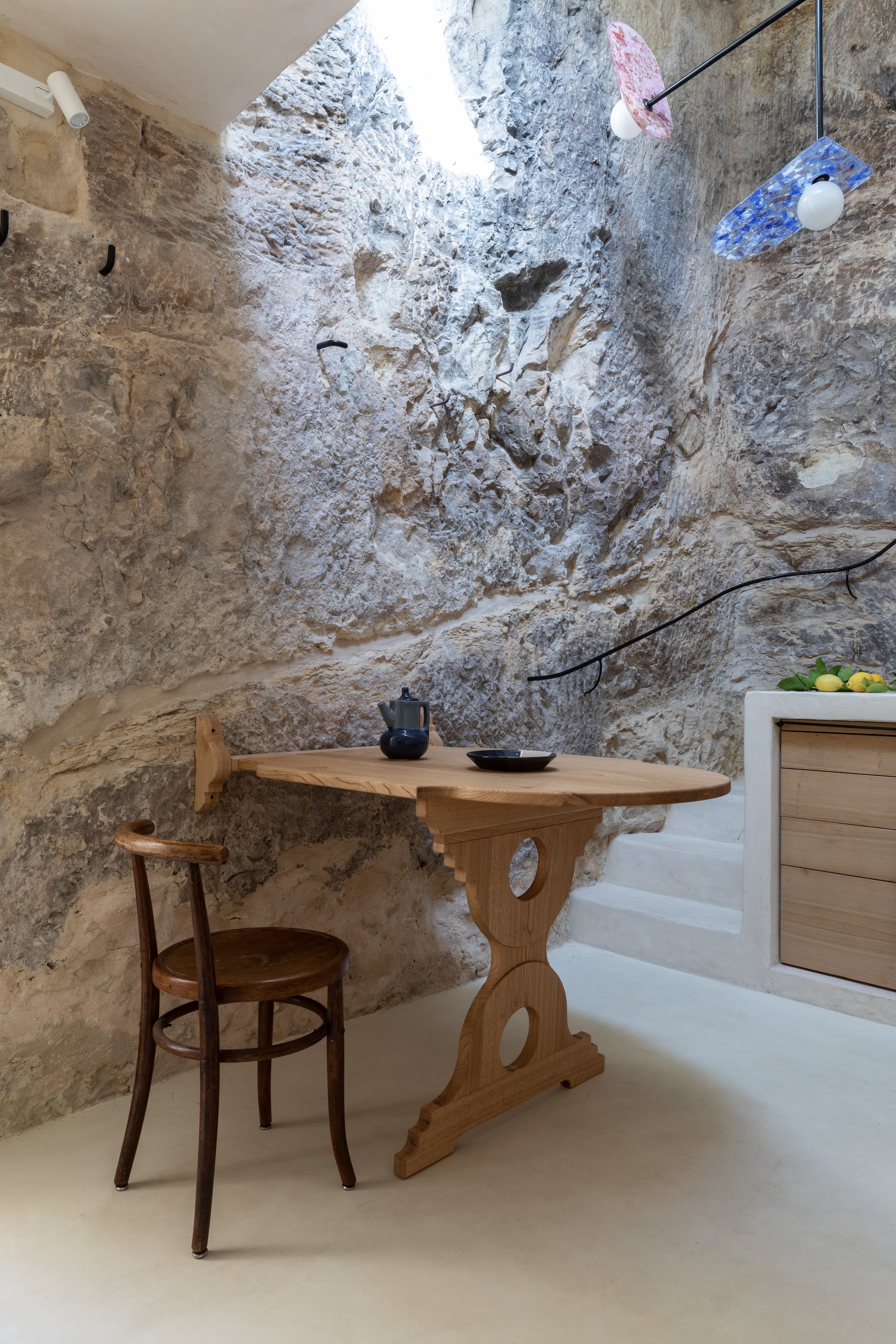 Op maat gemaakt kastanjehouten tafel naar traditioneel grotwoningmodel. Hanglampen van Il Fanale naar eigen ontwerp. vtwonen 08-2025 | productie Living Inside | fotografie Monica Spezia