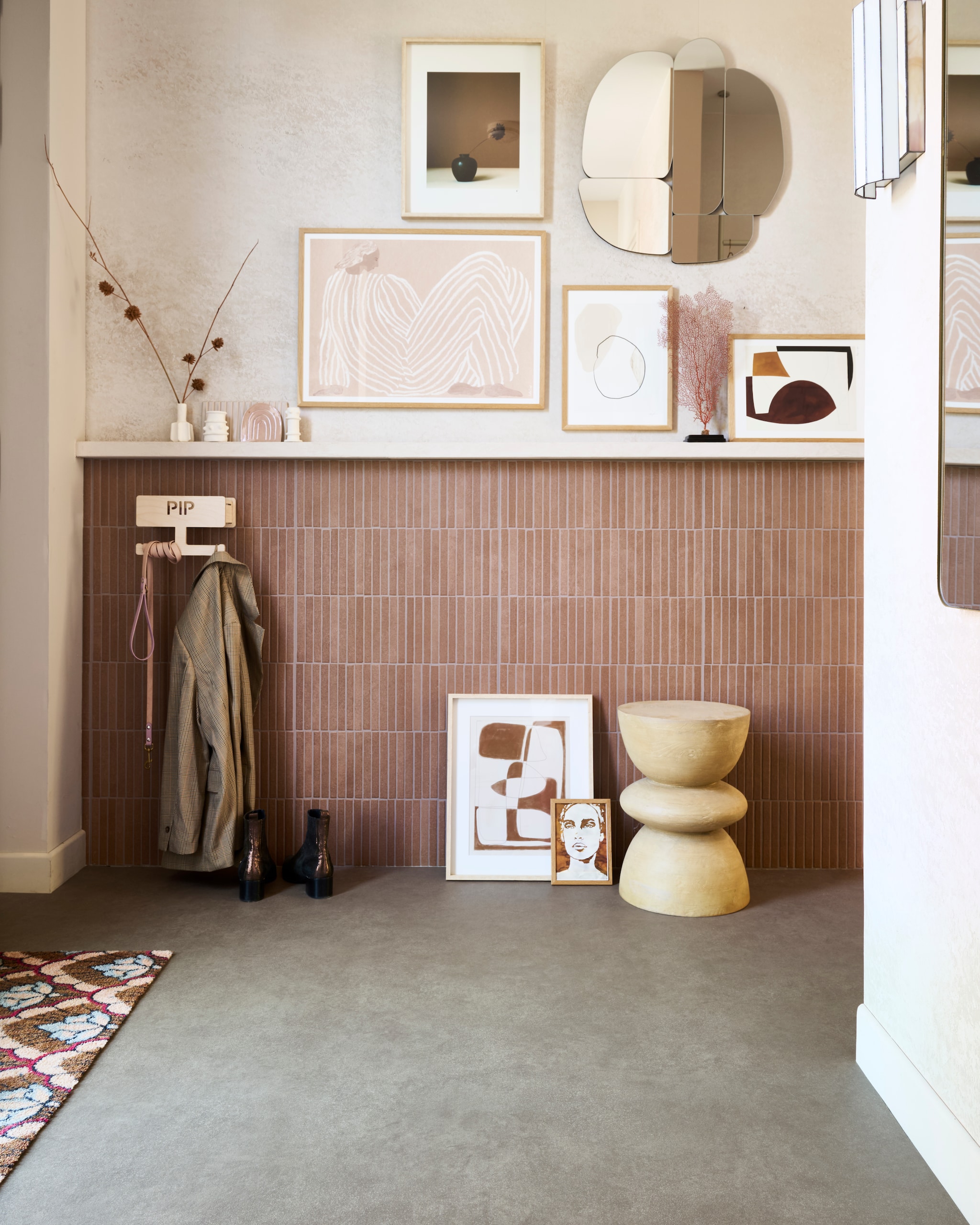 vtwonen Novilon Sandstone, earth (2114), per m² € 36,75 (exclusief leggen).M.m.v. photowall.com (behang Flutter White), designtegels.nl (tegels), lxmatten.com (inloopmat). Overig privébezit. vtwonen 08-2025 | styling Kim van Rossenberg | fotografie Sjoerd Eickmans
