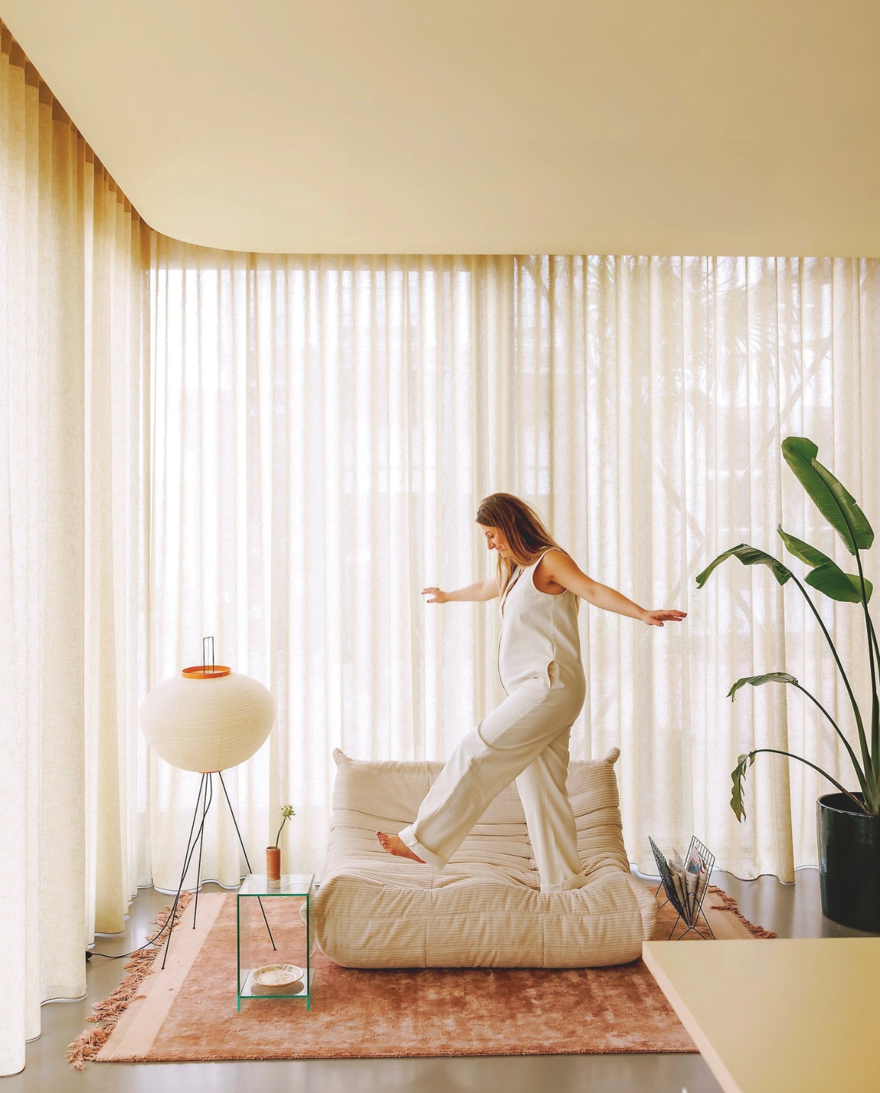 Plafondkleur Asian Sunrise van Lab Paint. Gordijnen Nuzzle in Olijfgroen van Vadain. PU-gietvloer Senso. Vloerlamp Akari van Vitra. Vloerkleed Zuiver. Krantenhouder en glazen bijzettafel kringloop. Keramieken bord Sensi Studio. Keramieken vaasje zelfgedraaid door Kelly. Plant en pot via Daluto Palmen en Exotan. vtwonen 06-2025 | styling Kelly van Gendt | fotografie Emma Peijnenburg | tekst Jackie Oomen