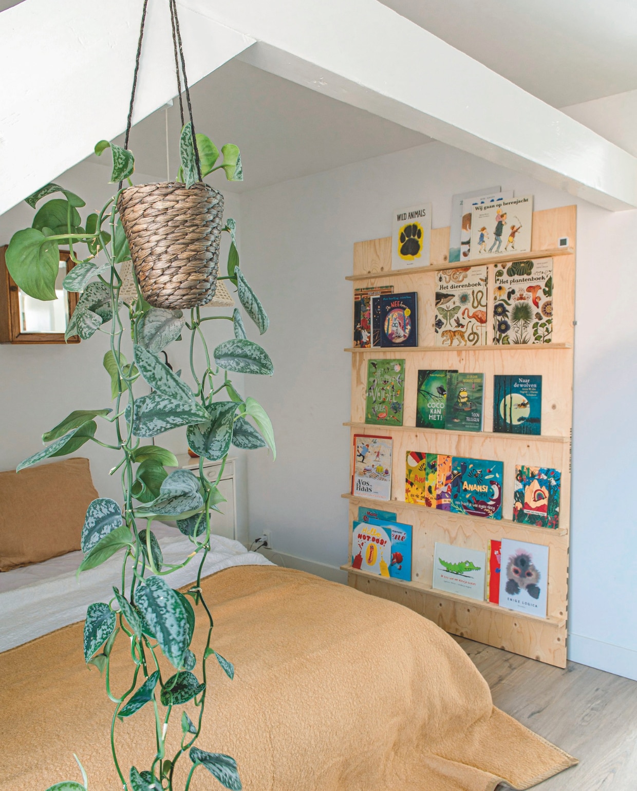 Beddensprei via Marktplaats, boekenplank zelfgemaakt, spiegelkastje via vrijmarkt op Koningsdag, plantenhangmand Hema. vtwonen 06-2025 | styling Jeske Weel| fotografie Caroline Coehorst