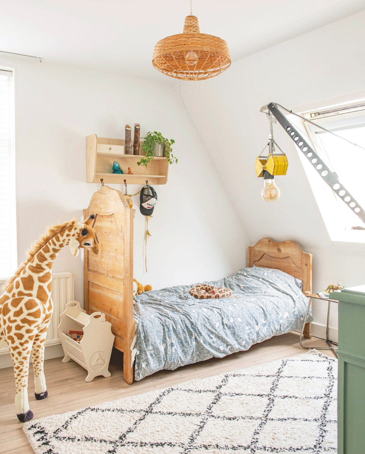 Hanglamp Ikea, bed uit vintagewinkel, beddengoed Garbo and Friends. Lectuurbak kringloopwinkel, kruk Marktplaats. Vloerkleed Karwei. Wandrek en groene kast Firma Zoethout. Giraffe Melissa and Doug Toys, slang Artis, blauwe vos Ikea, houten vos Ostheimer. Pet Maed for Mini. Vintage auto waarvan lamp is gemaakt via @checkstan. vtwonen 06-2025 | styling Jeske Weel | fotografie Caroline Coehorst