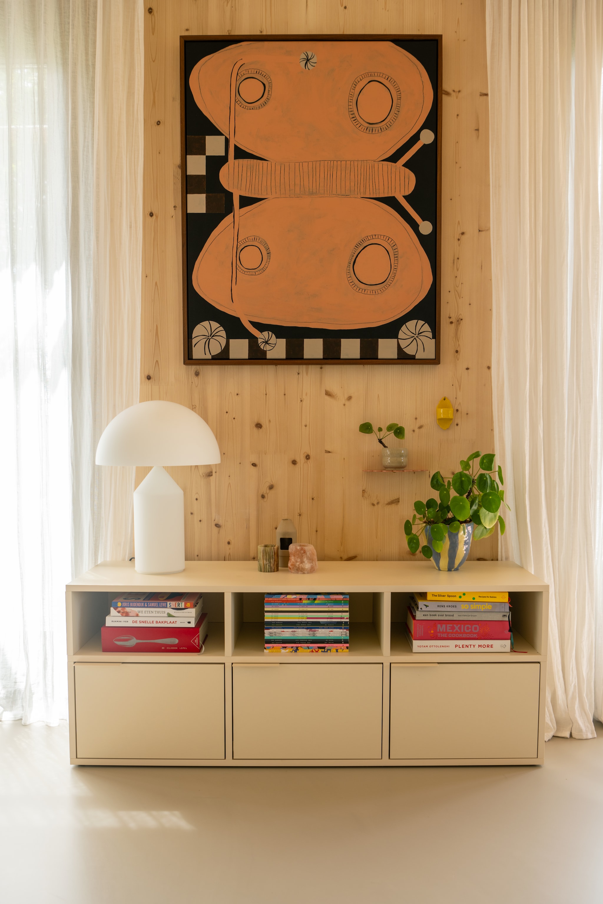 Schilderij Susan Meinen, kast Tylko, lamp Atollo van Oluce. Plantenpot gemaakt door Jesse, gordijnen H&M Home. vtwonen 09-2025 | styling Jasmijn Stegeman | fotografie Anke Leunissen