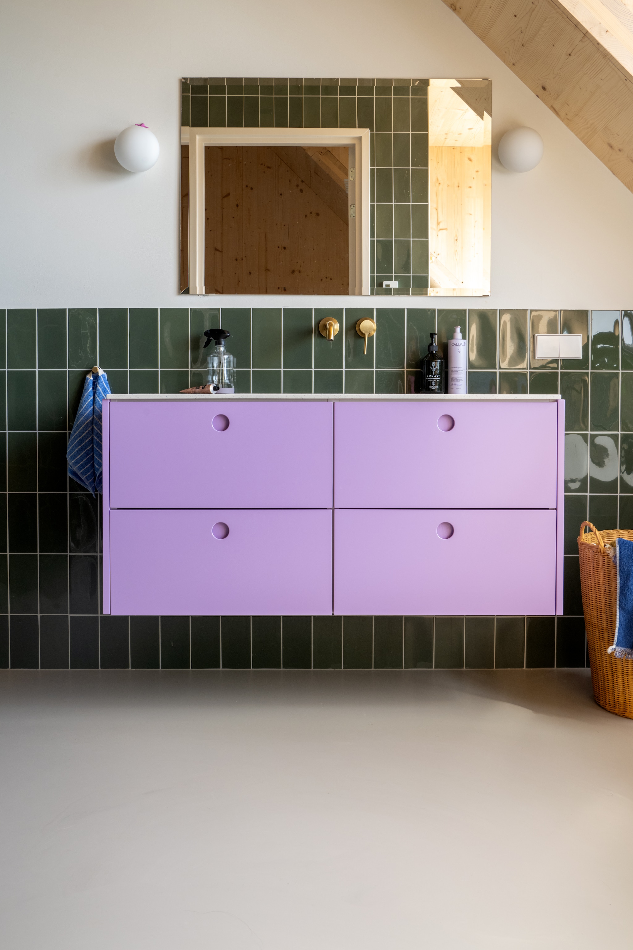 Wastafelmeuel Reform, spiegel vintage. Lampen Dioscuri van Artemide. Kraan Lusso, tegels Mosa. Wasmand Zara Home. Muurkleur RAL 9010. vtwonen 09-2025 | styling Jasmijn Stegeman | fotografie Anke Leunissen