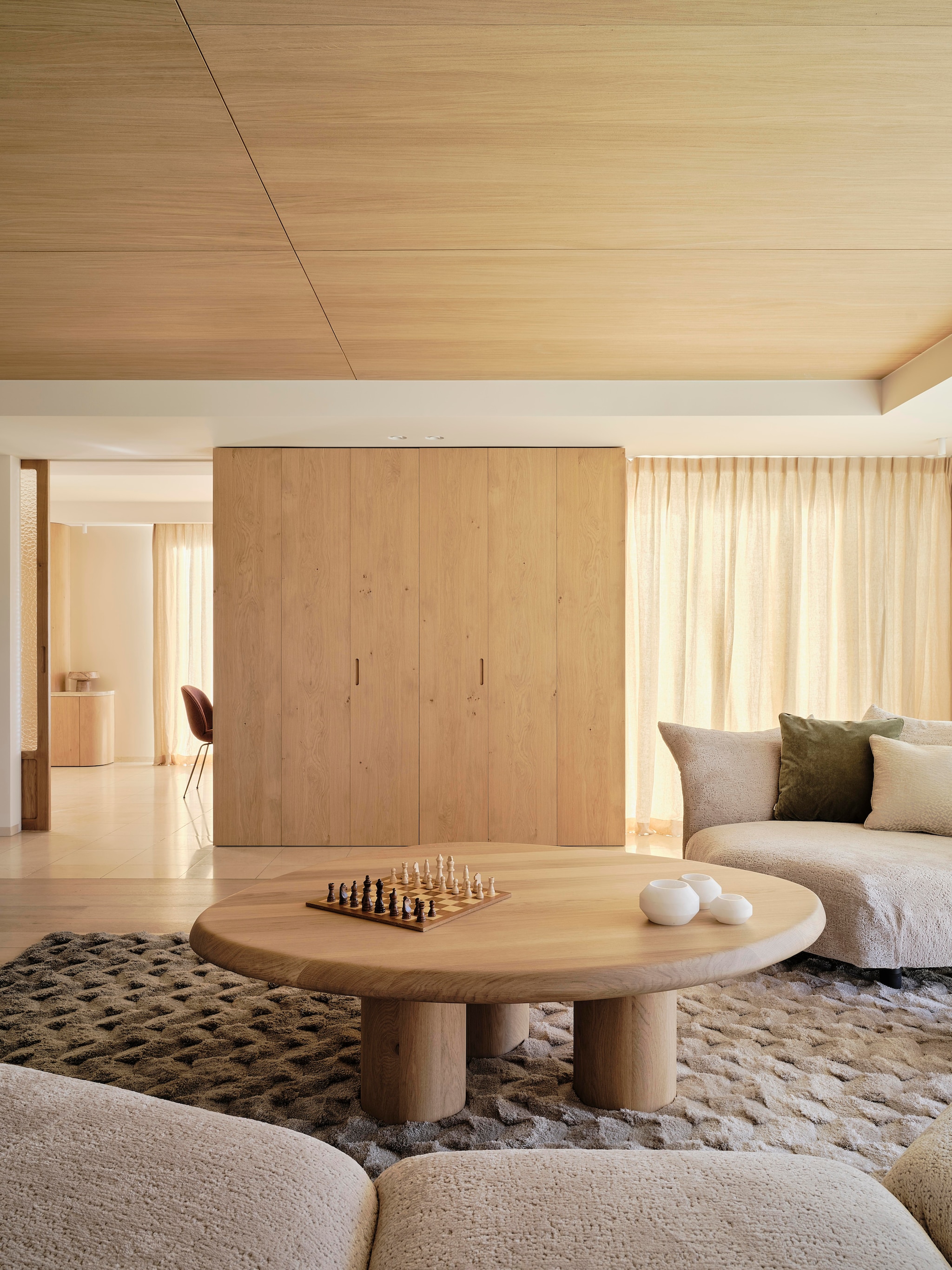 Modulaire bank Edra. Kussens gemaakt door Stoffeershop en bekleed met stof van Dedar en Zimmer + Rohde. Kleed Ferreira de Sá. Tafel Behout. Vazen Serax. Items planken links Maravillas, items planken rechts Roomer Art, Serax, HKliving. Tafellamp Oluce Atollo. Schouw Dover wit marmer. Zeegras behang Kudzu van Arte. stijlvol wonen 8-2025 | fotografie Space Content Studio