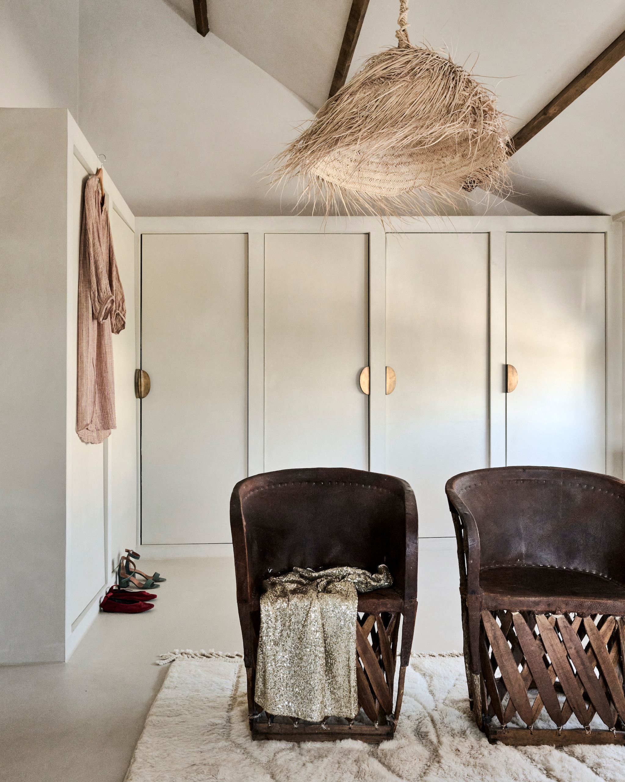 Kasten op maat gemaakt Holtzhaus. Leren Mexicaanse stoelen vintagemarkt Ibiza. Kleed The Souks. Lamp Ibiza Code. Jurken Numero 74 Ibiza en schoenen Paul Warmer. Op de muren L’ Authentique kalkverf kleur 230 Zand. Vloer steencement. vtwonen 08-2025 | styling Marianne Luning | fotografie Sjoerd Eickmans