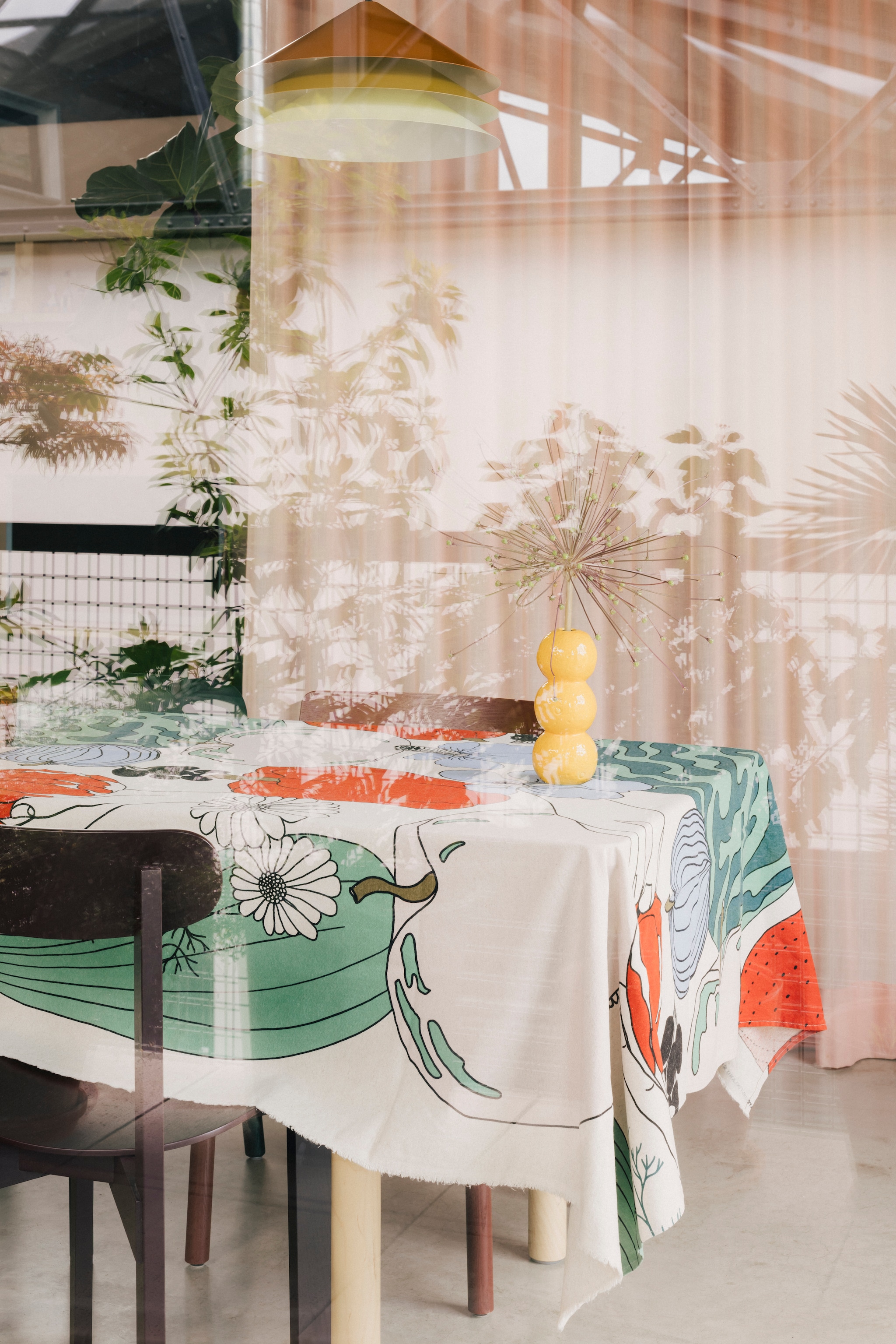 Eigen ontwerpen: gordijnen Tinctorial Textiles voor Ecological Textiles, karaf en hanglamp Tesammans voor Ikea. Groene stoel Soft Edge van Hay. Rode stoel Betty van &Tradition. Tafelkleed Marimekko. Vaasje Intratuin. stijlvol wonen 8-2025 | fotografie Katoo Peeters