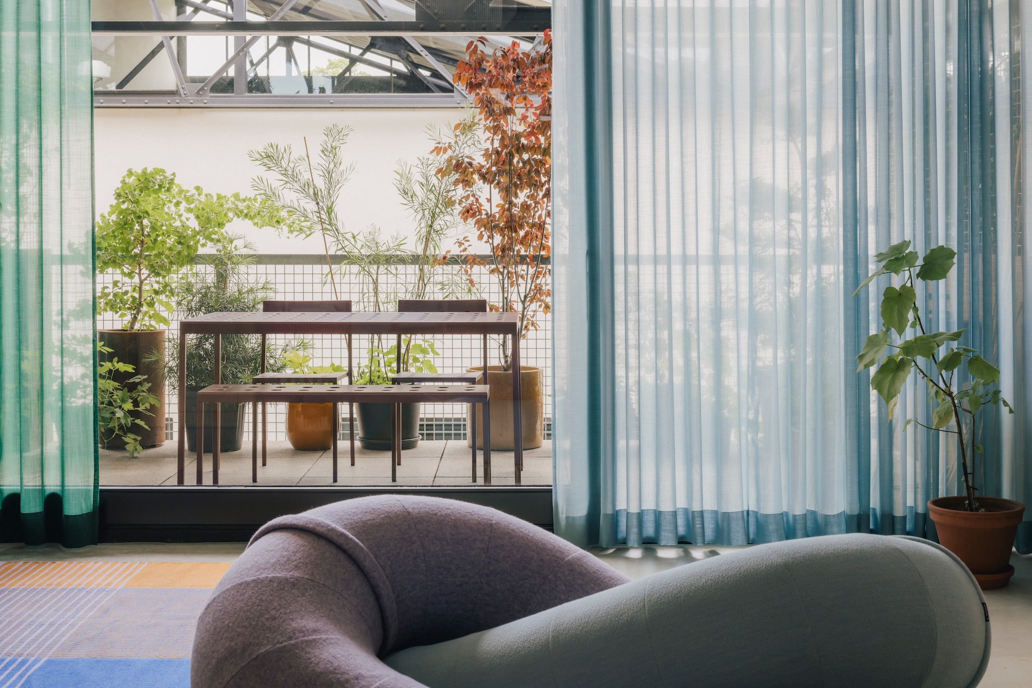 Eigen ontwerpen: bank Link voor Sancal en vloerkleed Tesammans voor Ikea. Tuinmeubels Balcony van Ronan en Erwan Bouroullec voor Hay. Gele plantenpot Ter Steege. stijlvol wonen 8-2025 | fotografie Katoo Peeters