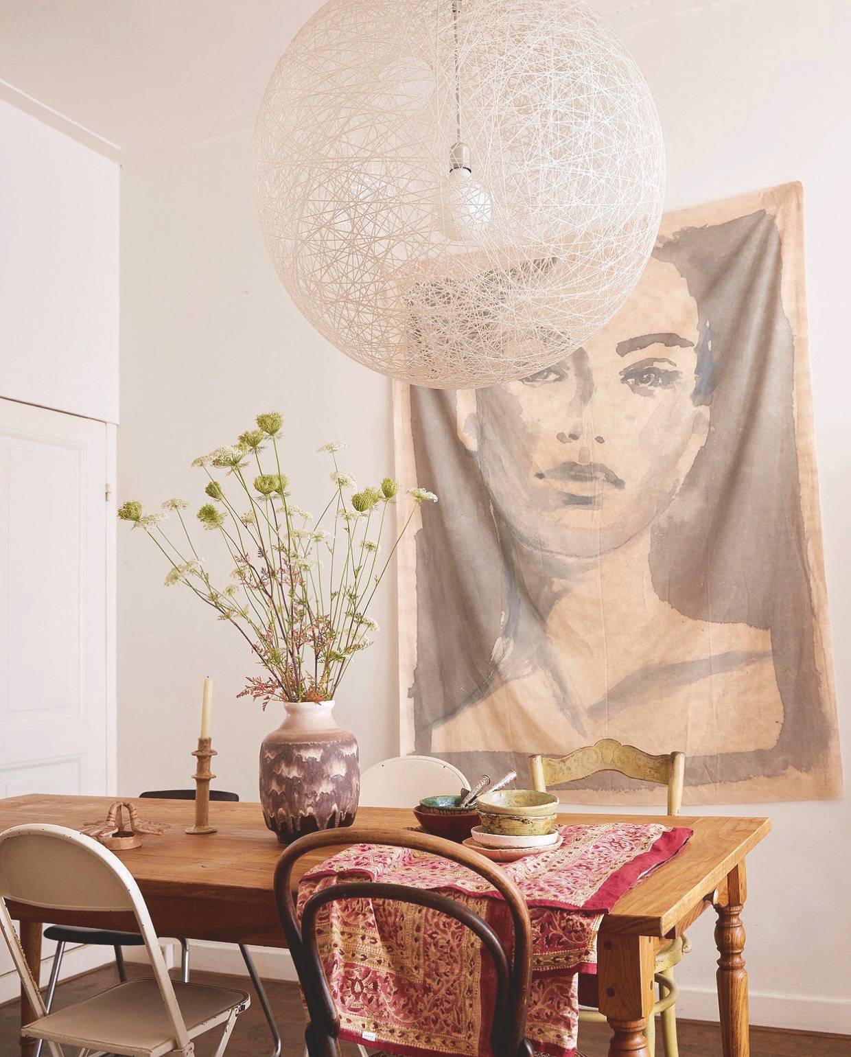 Wanddoek op ecokatoen tinystories. Lamp Random Light van Bertjan Pot via Moooi. Tafel gemaakt door timmerman. Stoelen, vaas en keramiek  diverse rommelmarkten. vtwonen 7-2025 | styling Marianne Luning | fotografie Tjitske van Leeuwen