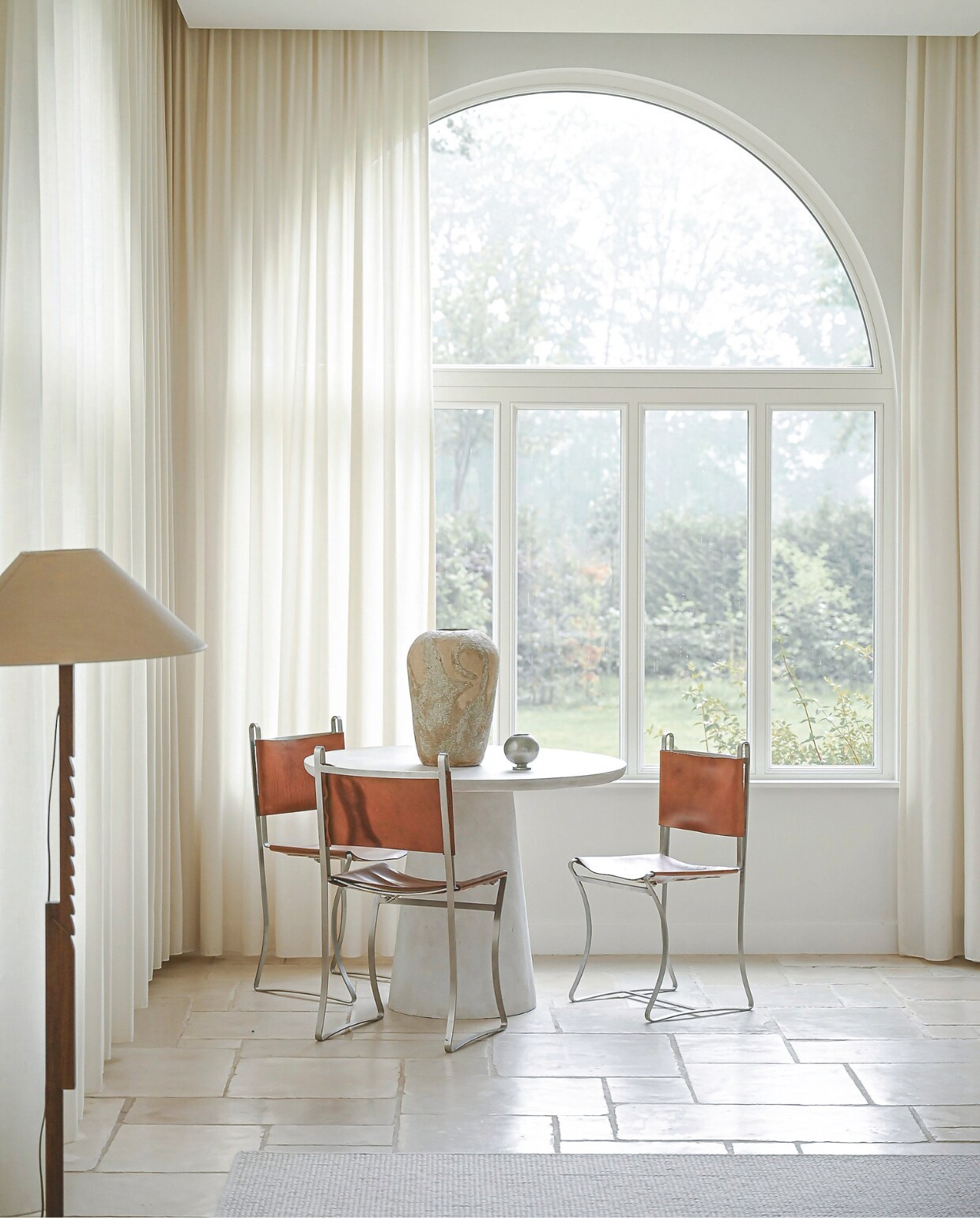 Betonnen tafel Woood. Vaas A. Gallery. Franse chromen en leren eetkamerstoelen en lamp vintage. Stijlvol Wonen 06-2025 | fotografie Michiel Bosman