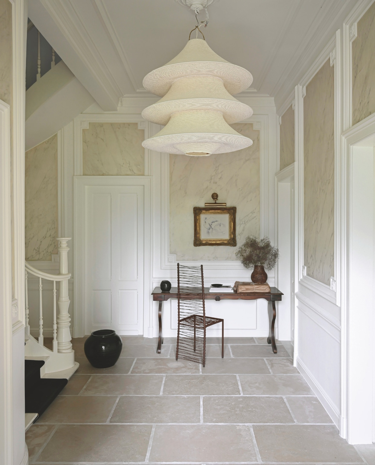 Hanglamp van Hamimi is met de hand gehaakt in Marokko. De met marmertechniek beschilderde muren zijn authentiek. Bibliotheektafel van Kates overgrootouders. Kunstwerken gemaakt door Kate. IJzeren stoel HHart Design. Alle andere items zijn tweedehands. Stijlvol Wonen 06-2025 | fotografie Michiel Bosman