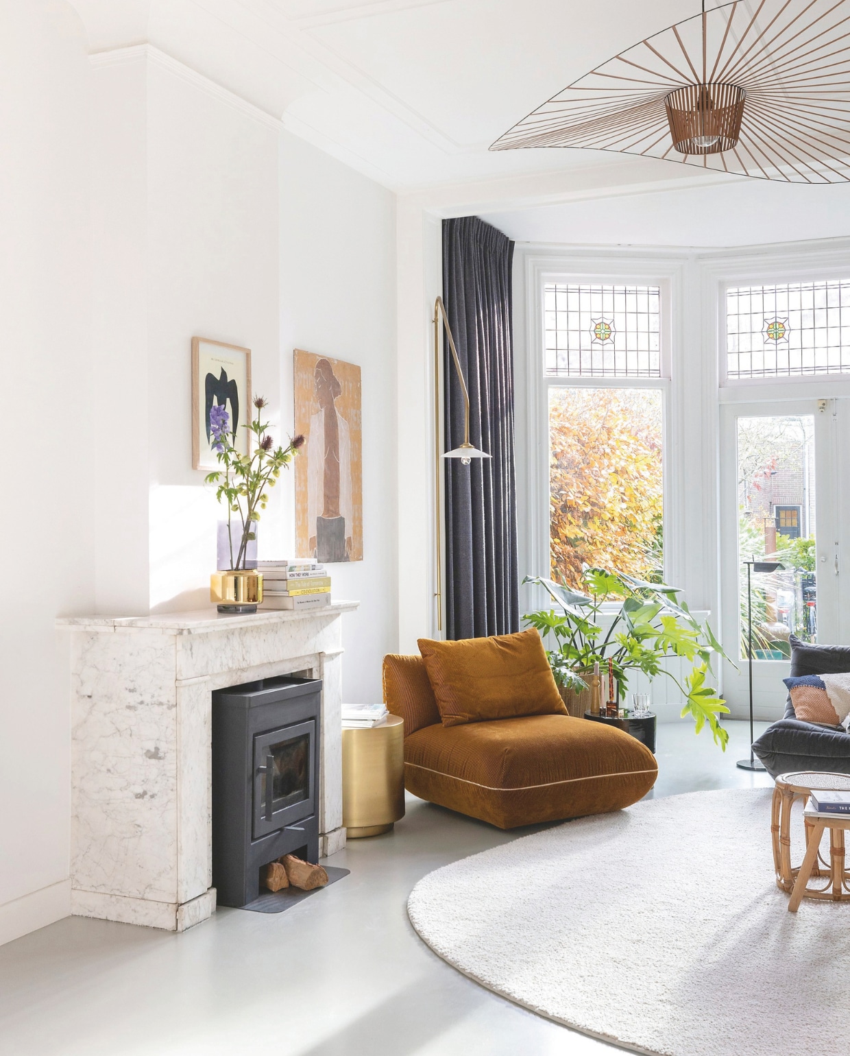 Camelkleurige bank en fauteuil Cor Design, fauteuil Ligne Roset, vloerkleed zelf ontworpen Jabo. Kussen HKliving, leeslamp Flos. Schilderij Casper Faassen. Epoxy gietvloer. Behang Arte. Kleur op de muur signaalwit van Karwei. vtwonen 7-2025 | fotografie Margriet Hoekstra | styling Room Rebelle