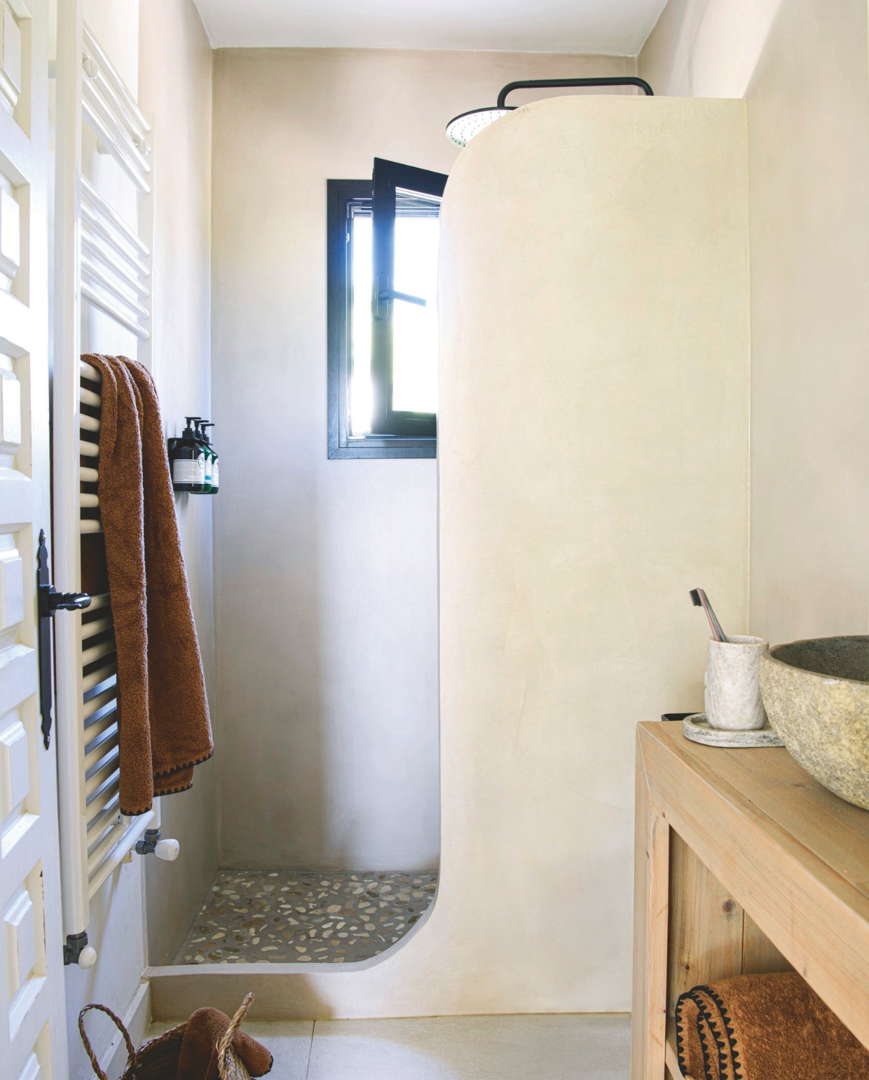 Douche op maat gemaakt met mortex. Vloer in douche, waskom, wastafelmeubel en rieten mand lokale winkel. Zeepbakje, tandenborstels en tandenborstelhouder House Doctor. Handdoeken Haomy. vtwonen 8-2025 | styling Inge van Lieshout | fotografie Louis Lemaire