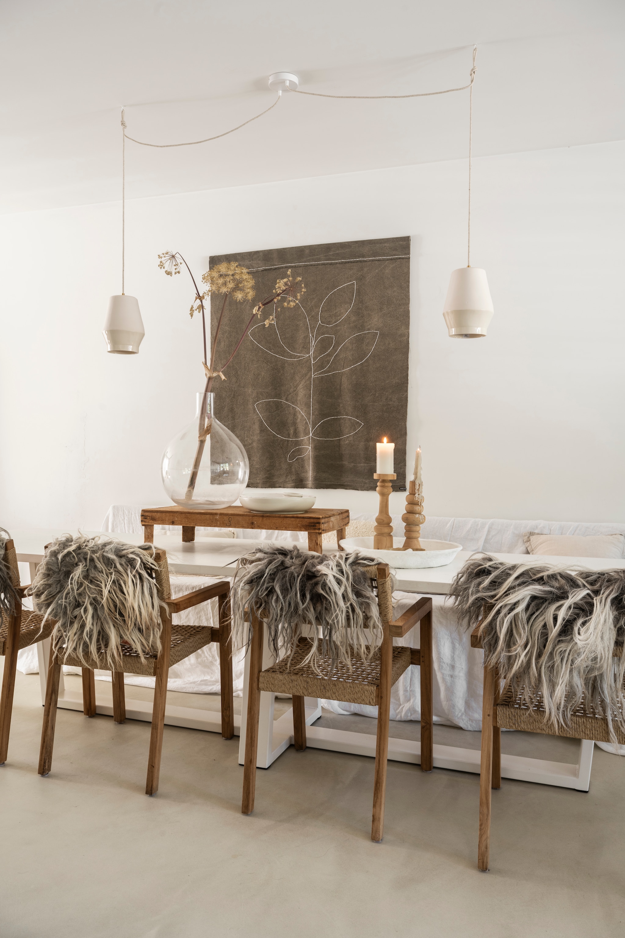 Maatwerk tafel Weij. Stoelen The Secret of Ogimi. Vachten Vacht van Vilt. Eetkamerbank Marktplaats. Hanglampen Great Ceramics. Houten plateau en kandelaars brocantemarkten. Linnen wandkleed Huize Jolie Gietvloer Behaaglijk Wonen. Vaas The Loving Wonen. vtwonen Landelijk 10-2025 | styling Marianne Luning | fotografie Stan Koolen