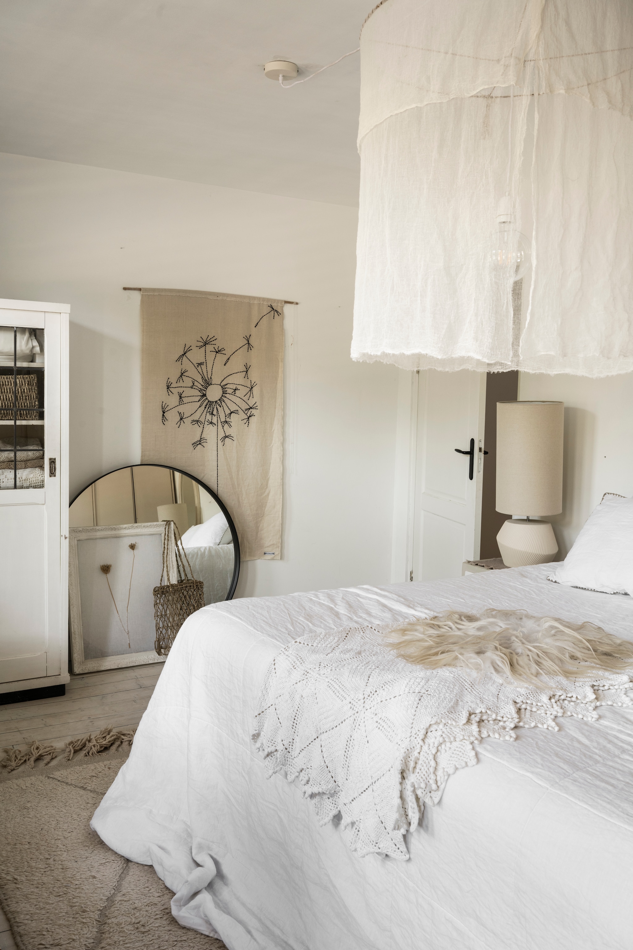 Notariskast vol linnen en oude gehaakte sprei, alles vintage. Schapenvacht Vacht van Vilt. Sfeerlamp Kwantum. Hanglamp Chérie Chérie. Beddengoed Coco & Cici. Vloerkleed Benio. Kunstwerken Huize Jolie. vtwonen Landelijk 10-2025 | styling Marianne Luning | fotografie Stan Koolen