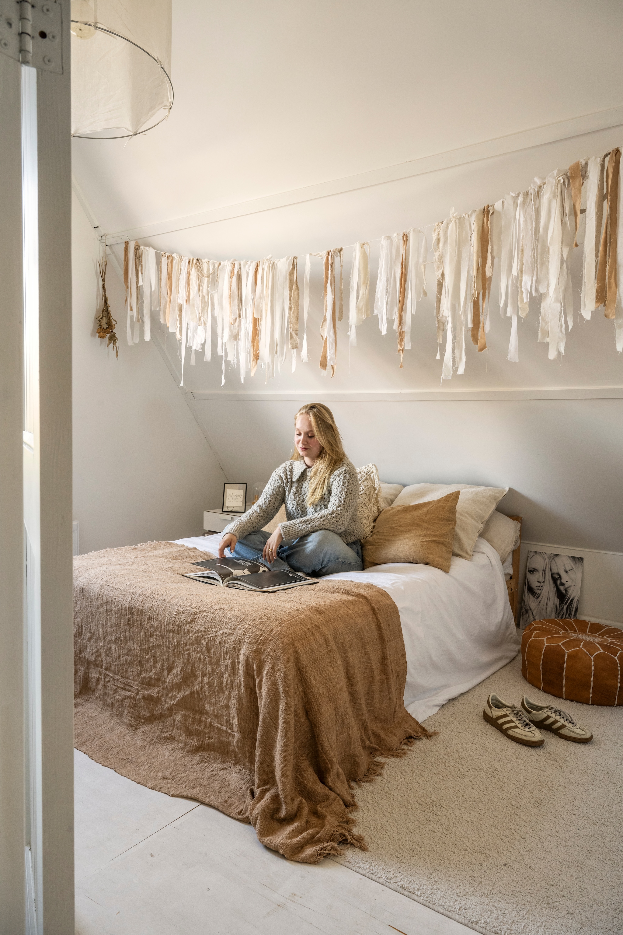 Slaapkamer van dochter Catelijne. Plaid en kussensPomax. Vloerkleed Kwantum. Beddengoed Coco & Cici. Leren poef uit Marokko. Slinger zelf gemaakt van restjes linnen. vtwonen Landelijk 10-2025 | styling Marianne Luning | fotografie Stan Koolen