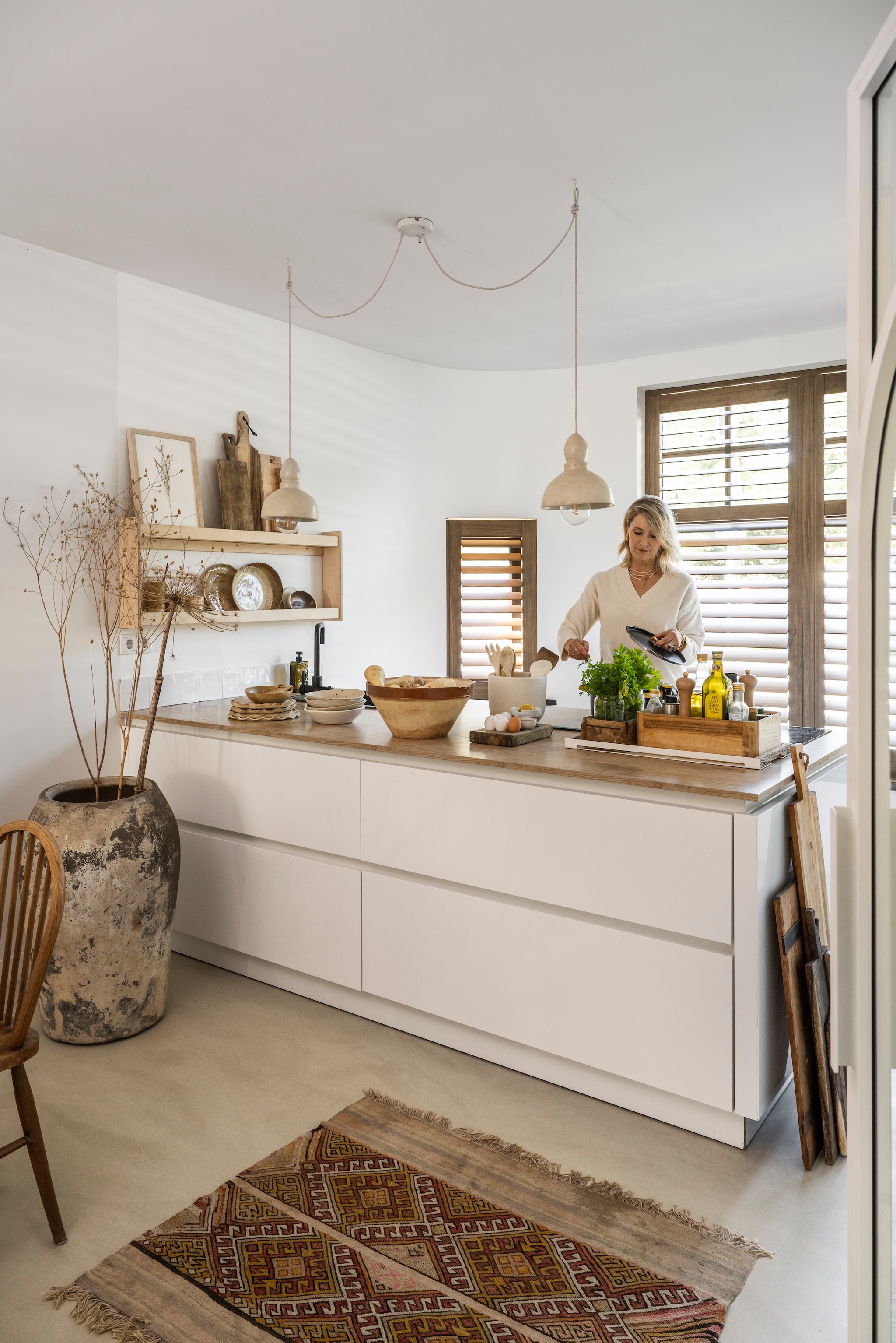Hoogglanskeuken met houten werkblad Superkeukens. Houten shutters Jasno. Gietvloer Behaaglijk Wonen. Vloerkleed uit Tunesië. Wit dienblad Robuust Maatwerk. Kruik Cooperz Wonen. Handzeep Ajen. vtwonen Landelijk 10-2025 | styling Marianne Luning | fotografie Stan Koolen