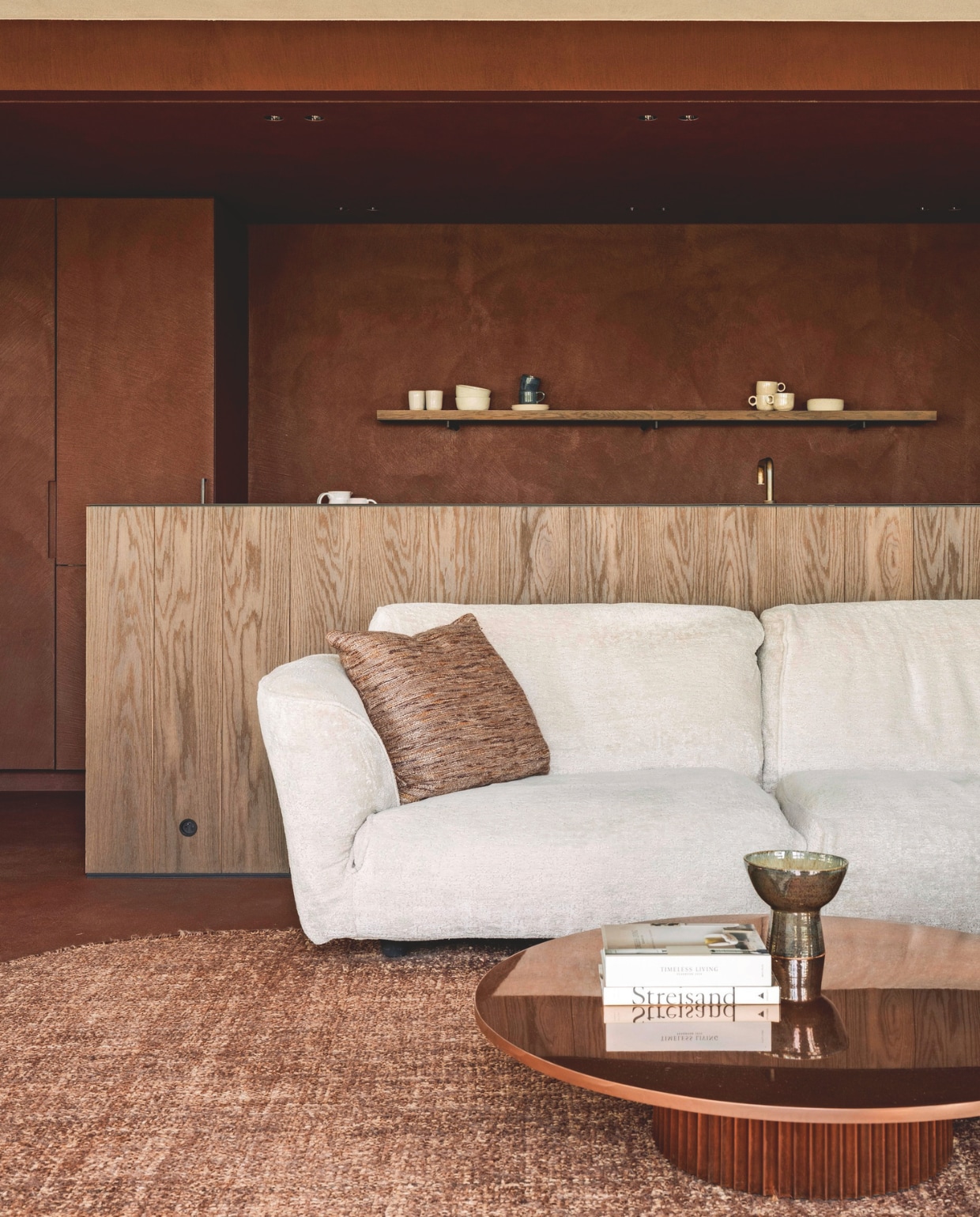 De open keuken en woonkamer zijn met elkaar verbonden. Op de wanden en vloer is Rasico stuc aangebracht, waardoor ze naadloos in elkaar overlopen. stijlvol wonen 7-2025 | fotografie Tijs Vervecken